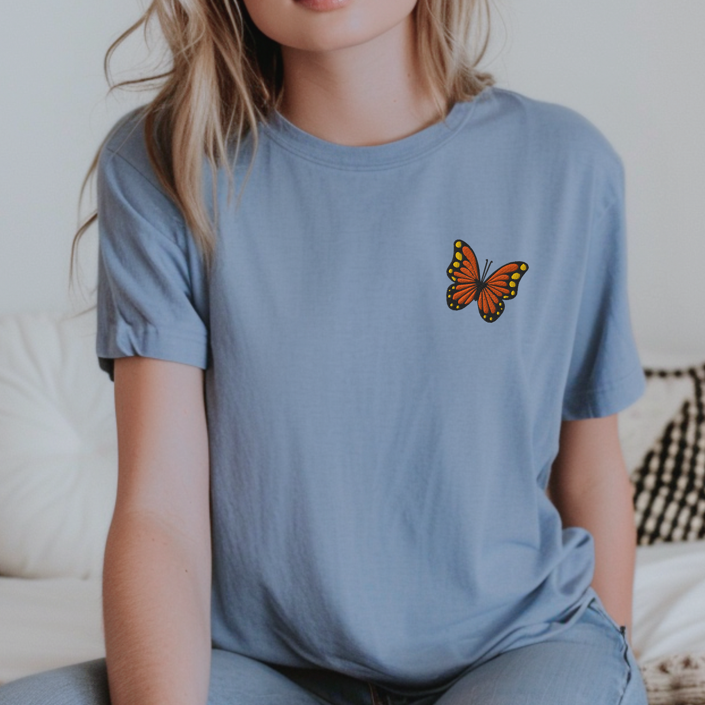 Image: Woman wearing a monarch butterfly embroidered shirt, capturing the spirit of slow fashion and spring renewal. This Comfort Colors tee is ideal for women who love boho fashion, rustic aesthetics, and quiet luxury basics. Great for gardening moms, Earth lovers, and those who find joy in small moments and simple clothes, by jaecrece.