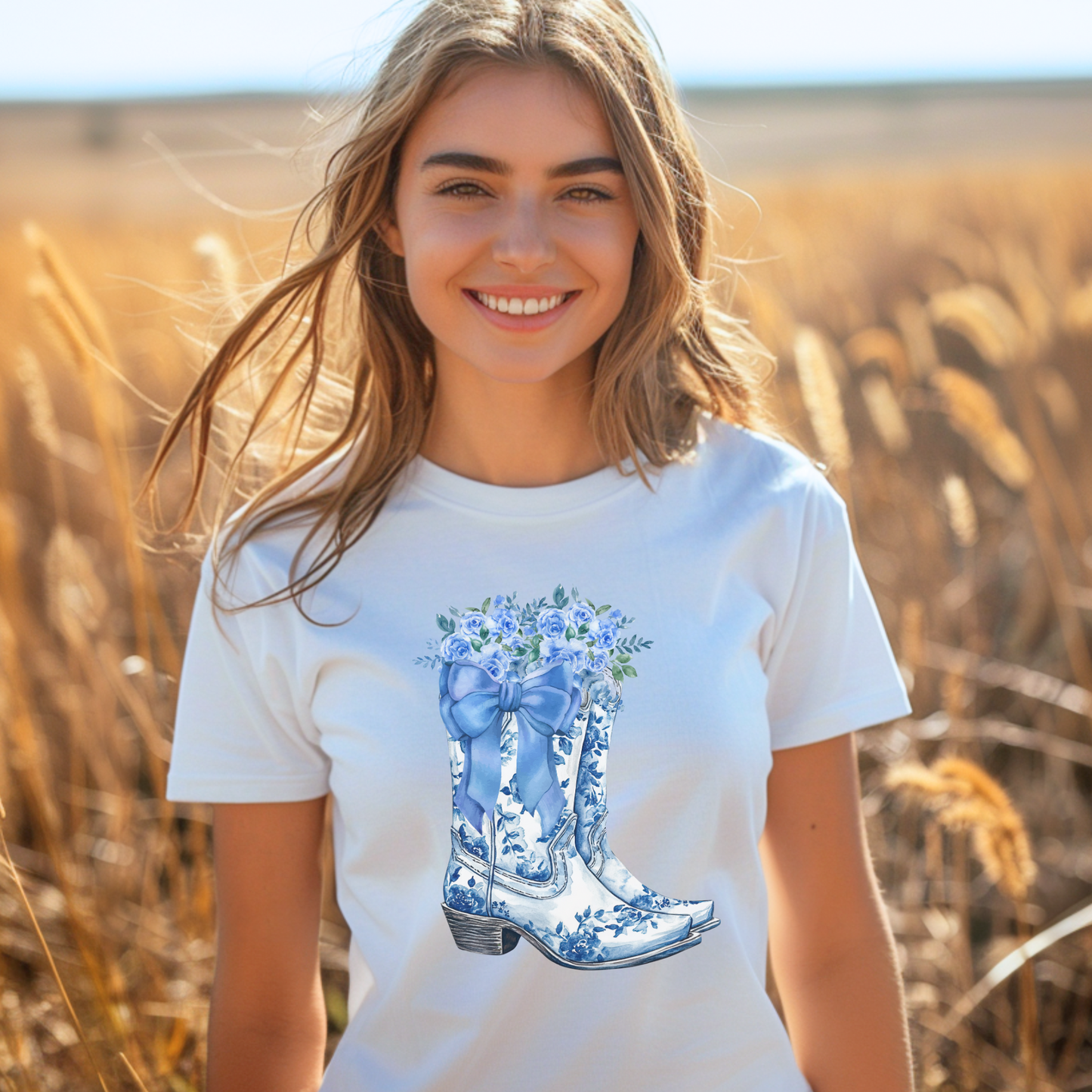 Image: Blue Toile Boots and Bows shirt in sizes for women. This pullover shirt features a pair of coastal cowgirl aesthetic cowboy boots with a blue bow and blue wildflowers. This country themed sweater makes a perfect gift for your daughter, or for the boujee mama in your life, by jaecrece