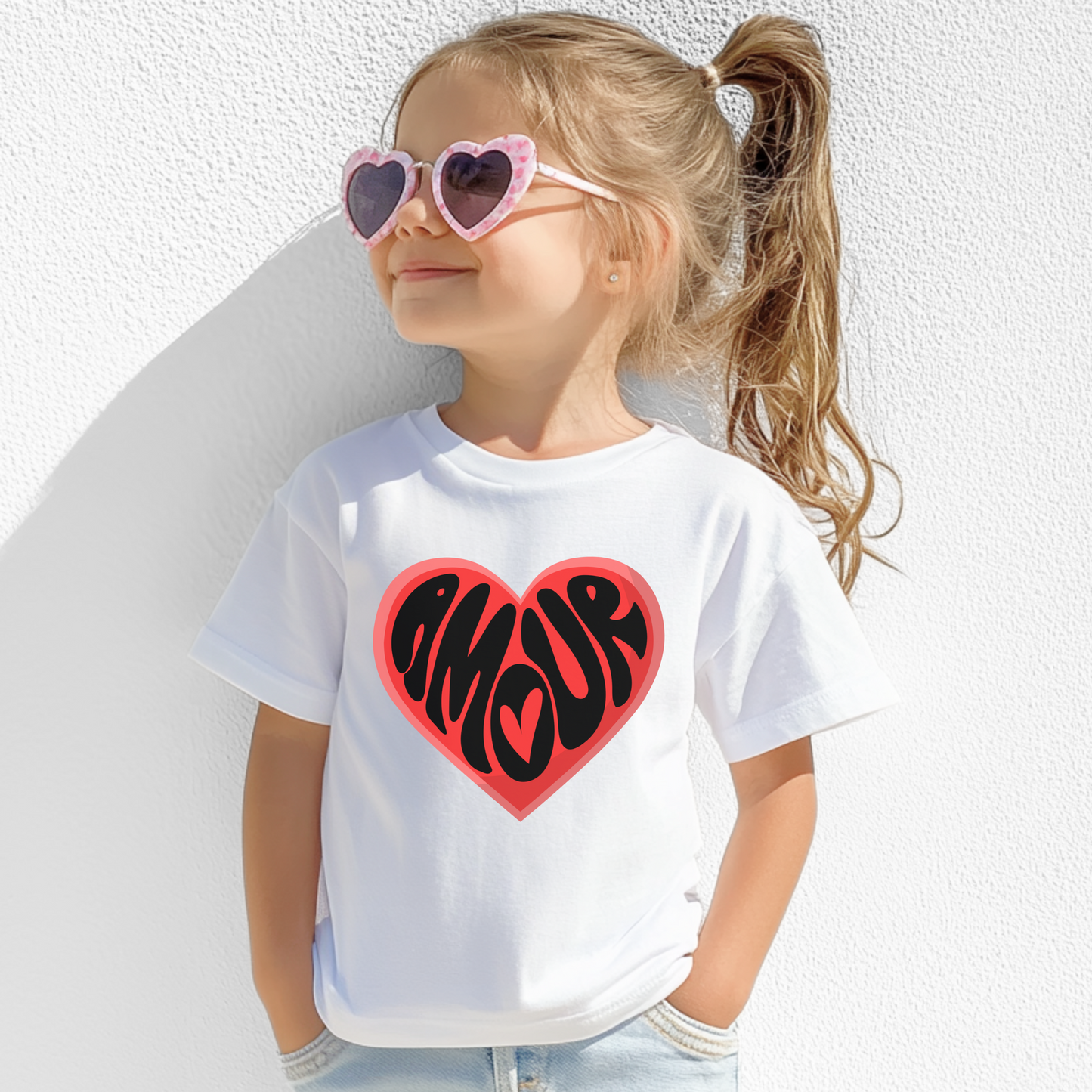 This Amour Love Girls T-shirt is a playful Parisian tee for Valentine’s Day, featuring a bold heart and the word "Amour" in a chic font. Sized XS–XL, it’s perfect for tweens and daughters who adore cute French fashion. The soft cotton makes it great for school parties, Galentine’s events, and mommy and me matching outfits. Designed for girls who love the coquette look, this shirt is a charming choice for Valentine photo shoots or casual outings.