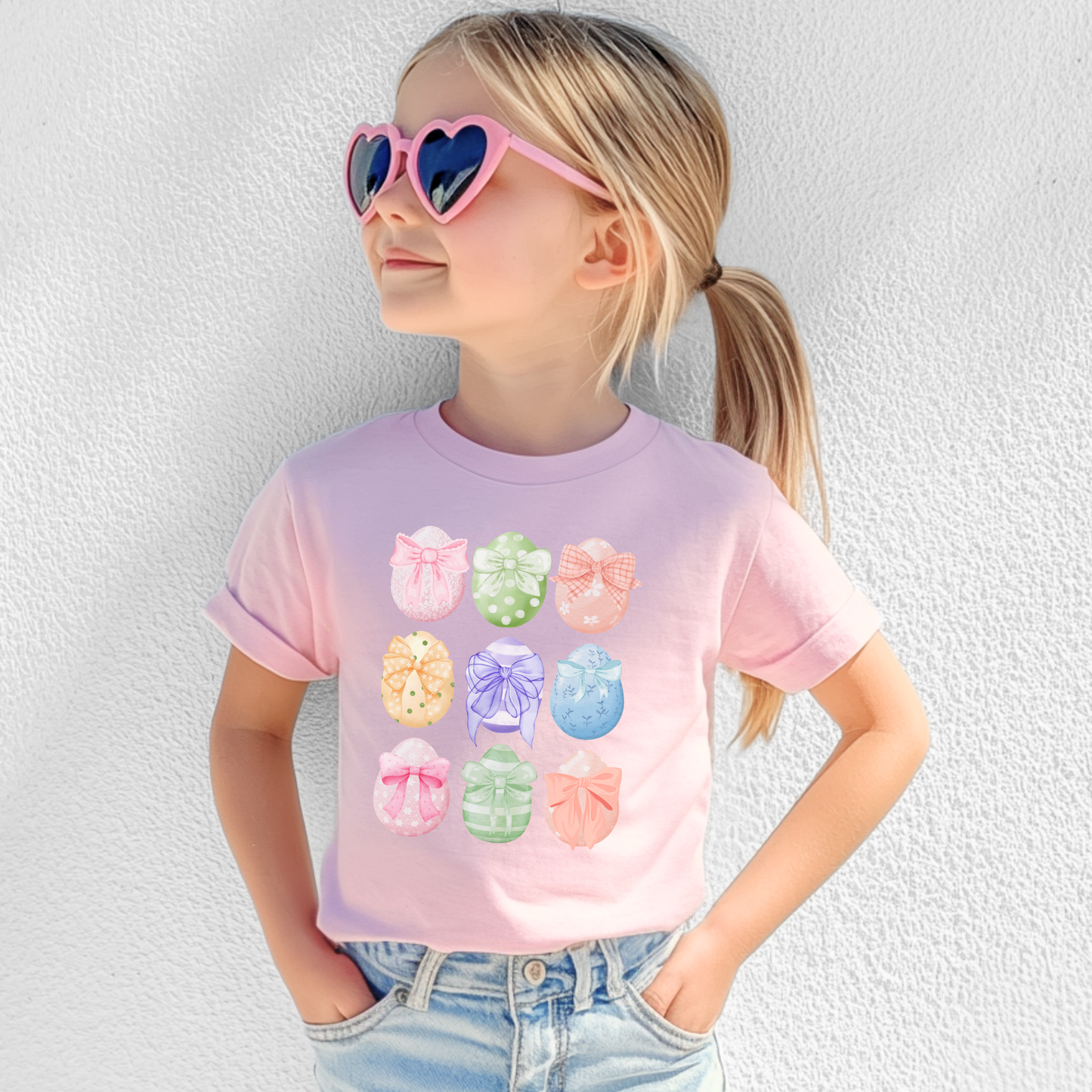 Image: Celebrate Easter with this adorable toddler shirt featuring nine watercolor eggs, each decorated with a dainty bow in coordinating pastel shades. This soft and stylish tee is perfect for spring festivities, making it an ideal choice for egg hunts, Easter brunch, and matching family outfits. With a charming design and cozy fit, this Easter tee is a wonderful gift idea and a great addition to any little girl’s wardrobe, by jaecrece.