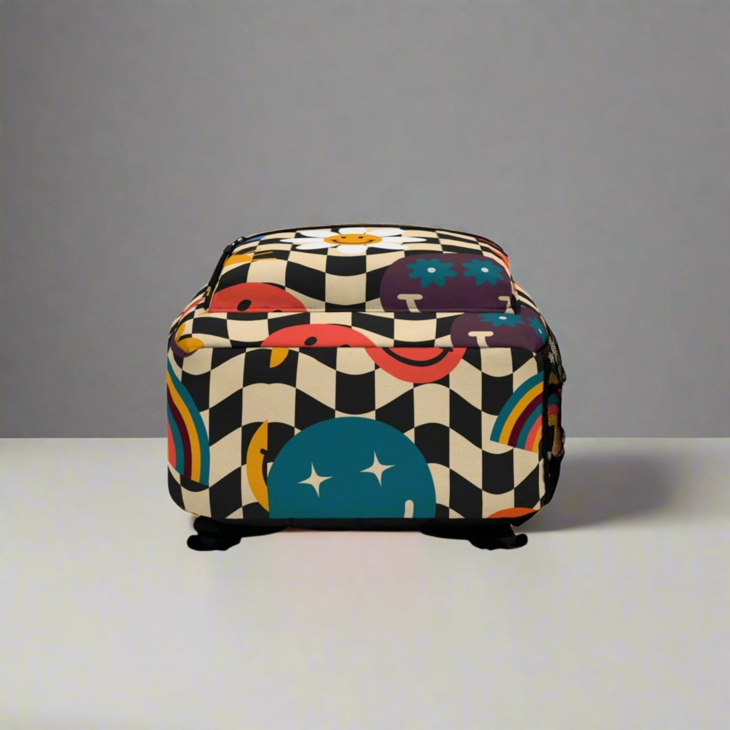 Image: Smiley Face Retro Checkerboard Backpack, with a black and tan checker pattern, and daisies, rainbows, suns and stars. The perfect vintage back to school bookbag for your hippie chick teen or tween, by jaecrece