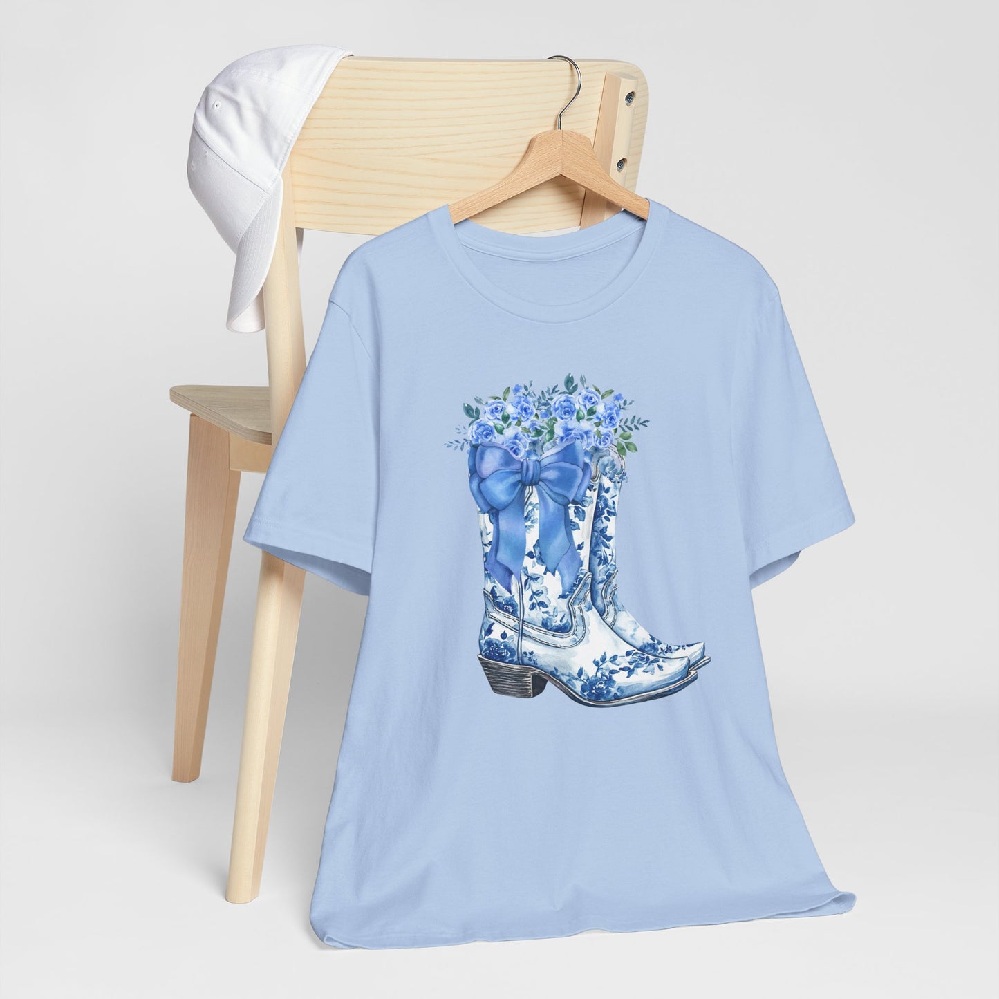 Image: Blue Toile Boots and Bows shirt in sizes for women. This pullover shirt features a pair of coastal cowgirl aesthetic cowboy boots with a blue bow and blue wildflowers. This country themed sweater makes a perfect gift for your daughter, or for the boujee mama in your life, by jaecrece