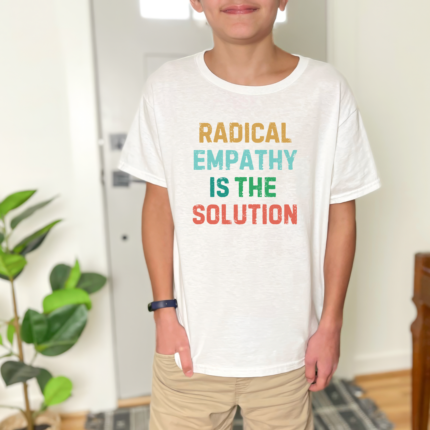 Image: A soft, comfortable kids' tee featuring the words "Radical Empathy is the Solution" in a bold, empowering design. Ideal for young activists, this shirt encourages kindness, understanding, and inclusivity. Whether for school, social events, or casual wear, this t-shirt helps kids express their values while staying stylish and comfortable, by jaecrece.