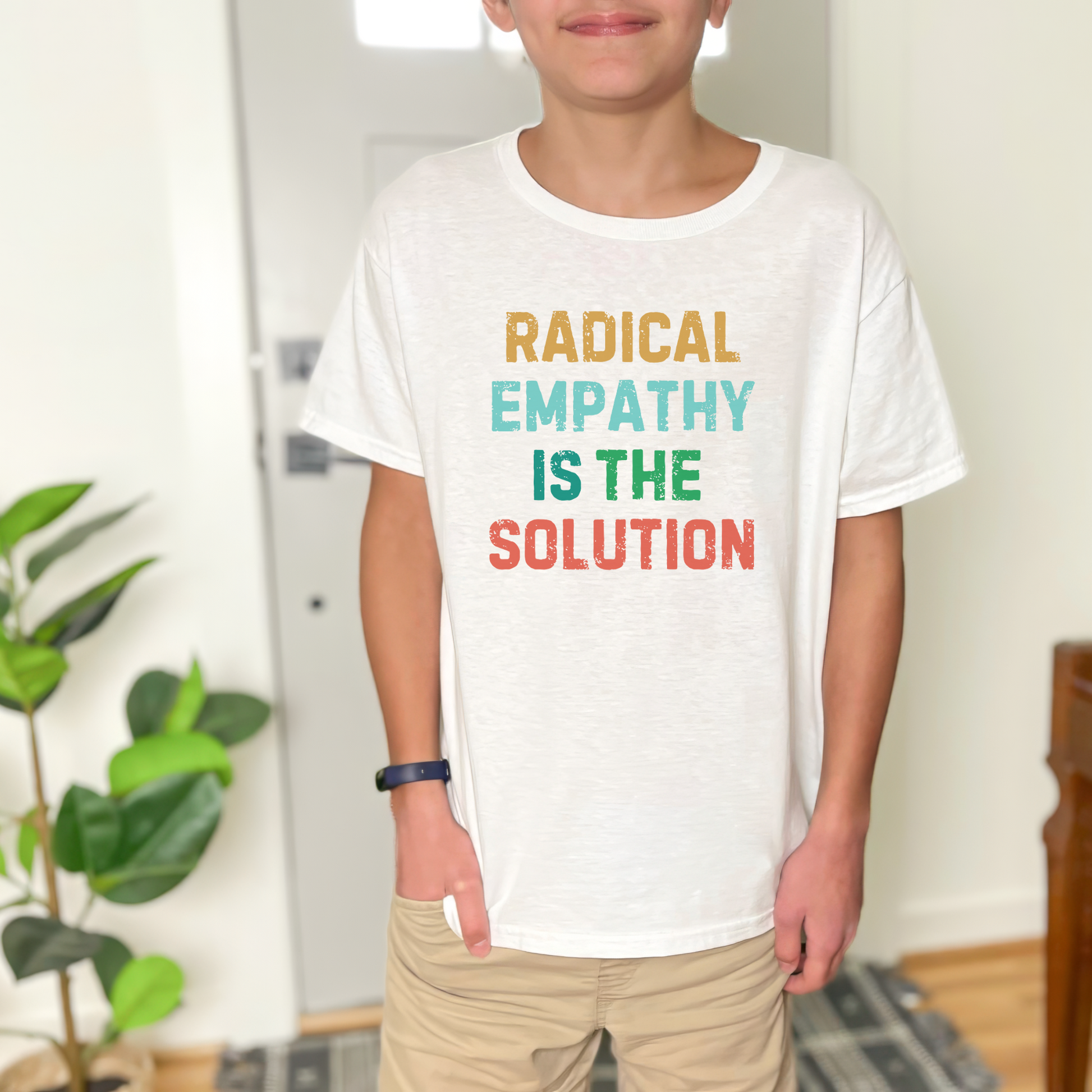 Image: A soft, comfortable kids' tee featuring the words "Radical Empathy is the Solution" in a bold, empowering design. Ideal for young activists, this shirt encourages kindness, understanding, and inclusivity. Whether for school, social events, or casual wear, this t-shirt helps kids express their values while staying stylish and comfortable, by jaecrece.