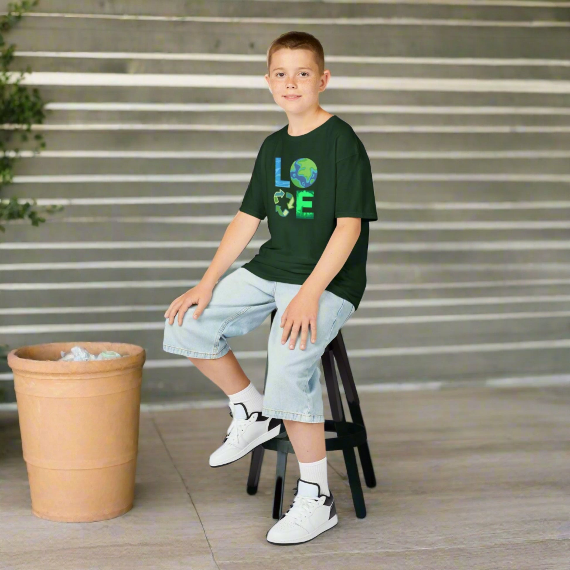 Image: A Love Earth Day shirt designed for kids, featuring bold letters that each symbolize an element of nature. The L resembles flowing water, the O is designed as the Earth, the V represents the reduce reuse recycle symbol, and the E is shaped like plants and trees. This eco friendly tee is perfect for Earth Day celebrations, environmental events, and spreading awareness about sustainability and conservation, by jaecrece.