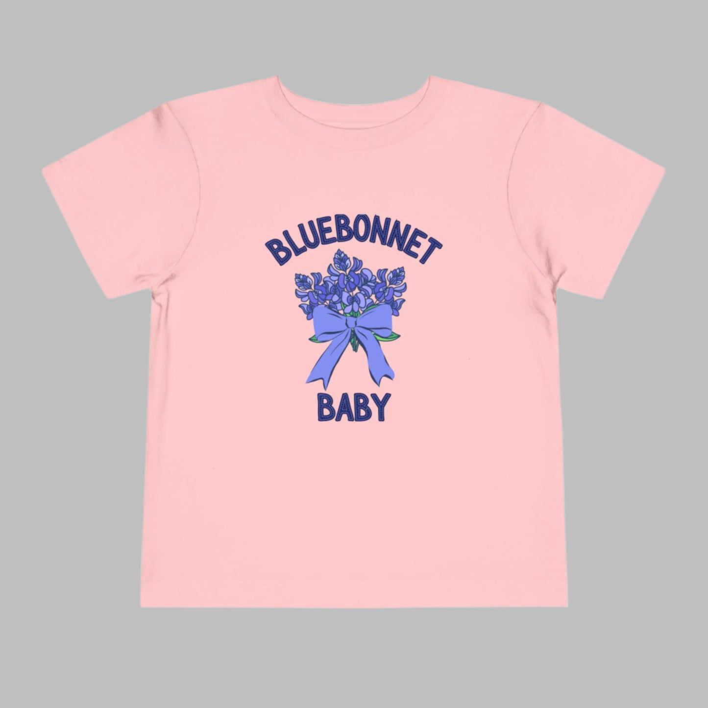 Image: A soft, breathable toddler t-shirt featuring a lovely bluebonnet print, celebrating the Texas state flower. Perfect for spring outings, this tee is ideal for bluebonnet field photos, playdates, or family picnics. A charming gift for baby showers or birthdays, it allows little Texans to embrace their roots. Its lightweight fabric ensures comfort while showcasing a nature-inspired design that makes any outfit extra special, by jaecrece.