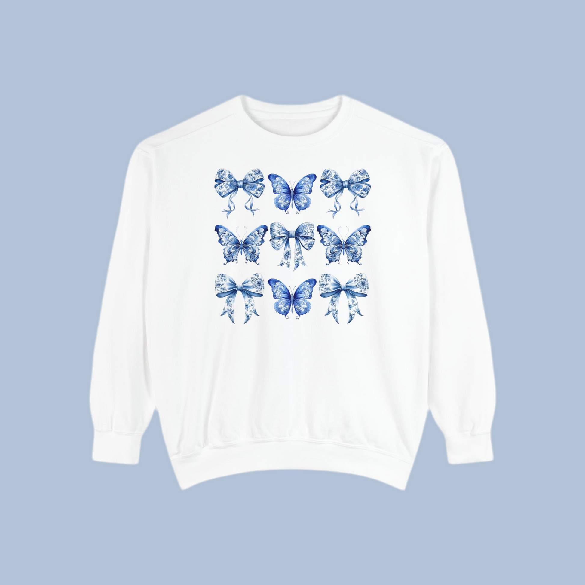 Image: Feminine women’s sweatshirt in charming blue toile design with whimsical butterflies and bows, great for cottagecore and spring fashion lovers. This piece fits into the Texas coquette trend with its graceful design and easy wearability. Match with toddler and youth pieces in our shop for a coordinated family outfit for holidays or birthdays, by jaecrece.