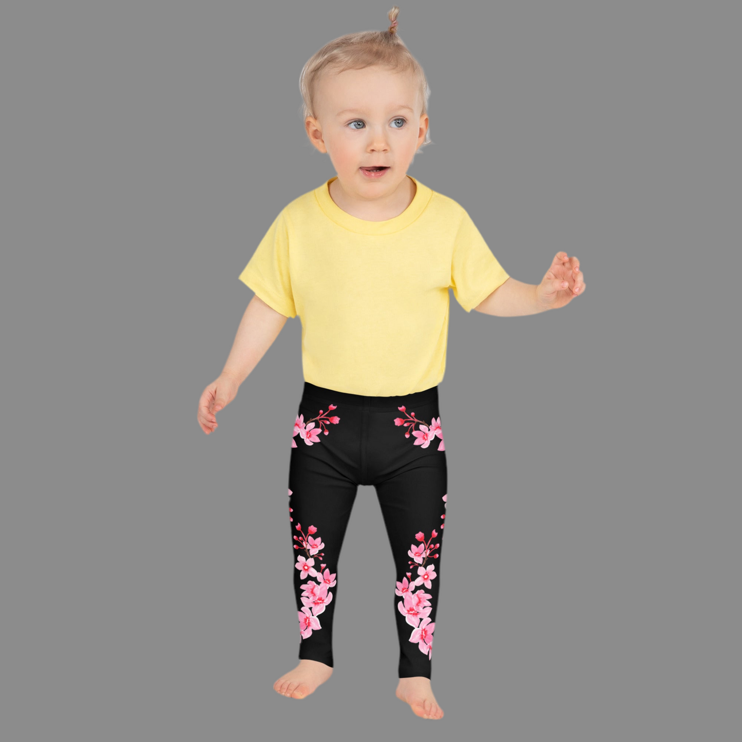 Image: Japanese Cherry Blossom Girls and Toddler Leggings, in sizes 2T, 3t, 4T, 5T, 6, 6X and 7. Black leggings with a swirl of Japanese cherry blossoms going down the outside of each leg. Elastic, soft, and durable with vibrant colors. Part of a matching collection for younger children and women, each pair is precision-cut and hand-sewn for a perfect fit.