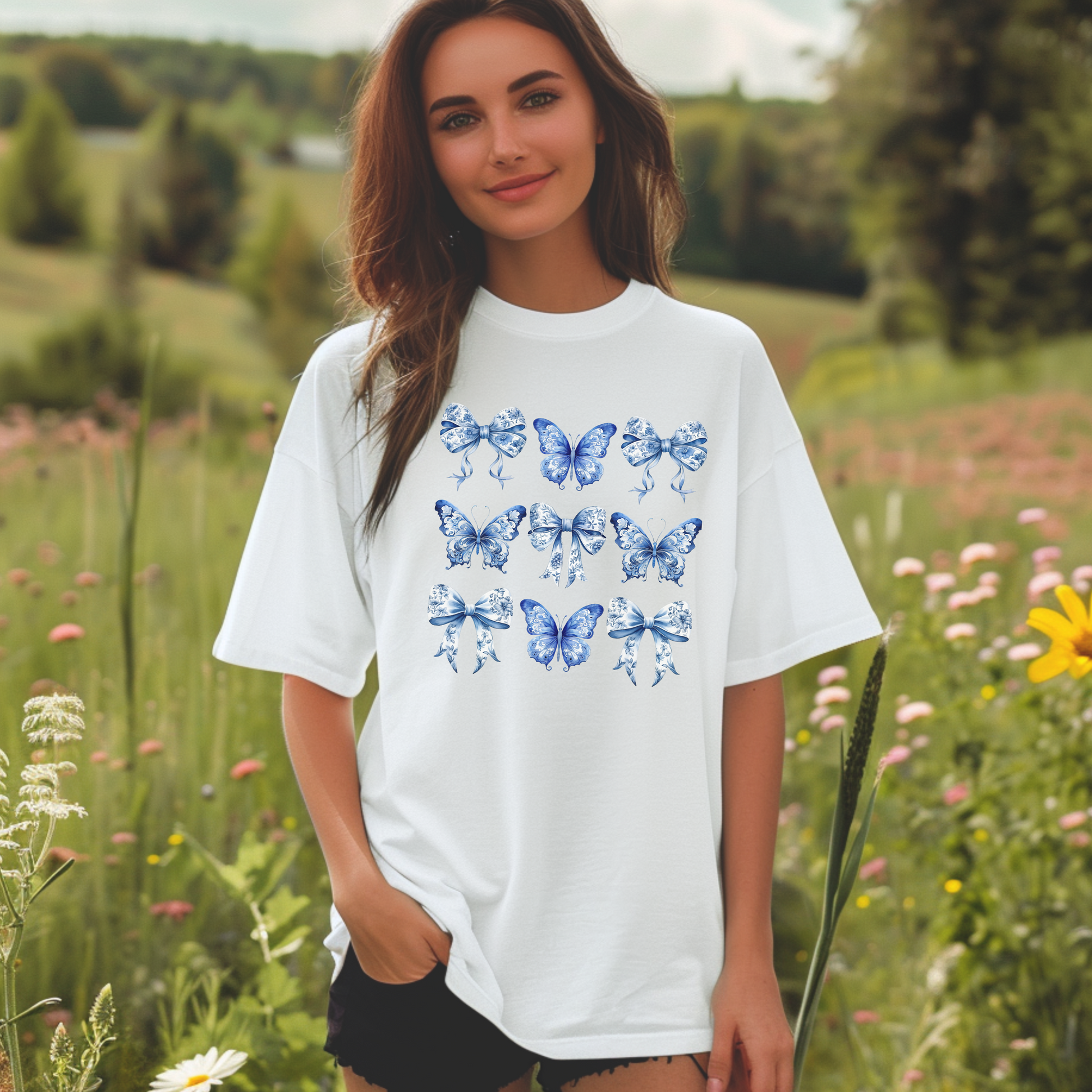 Image: With its dreamy butterfly and bow motif set against a vintage-inspired blue toile background, this women’s shirt blends soft girl style with French country elegance. A staple for bougie mamas and fans of the chinoiserie trend, it’s the perfect tee for family gatherings or spring strolls. Match it with girls’ and toddler sizes for an Instagram-ready mother-daughter look, by jaecrece.
