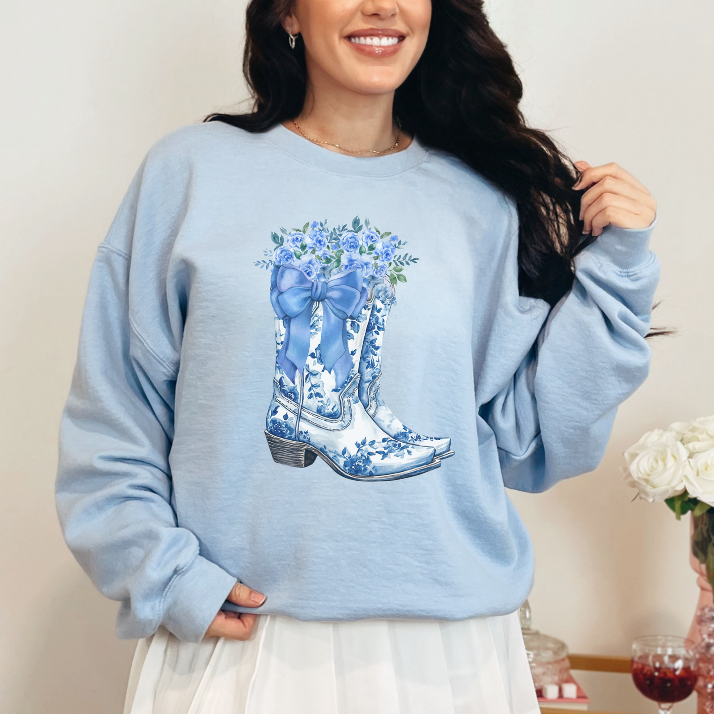 Image: A soft and stylish sweatshirt for women featuring a beautiful blue toile pattern with cowboy boots, bows, and wildflowers. Inspired by classic country elegance, this pullover blends vintage charm with a modern western feel. Perfect for coastal cowgirls, rodeo lovers, or anyone who enjoys feminine western fashion. A great gift idea for daughters, moms, or country-loving friends who appreciate a stylish yet cozy outfit, by jaecrece.
