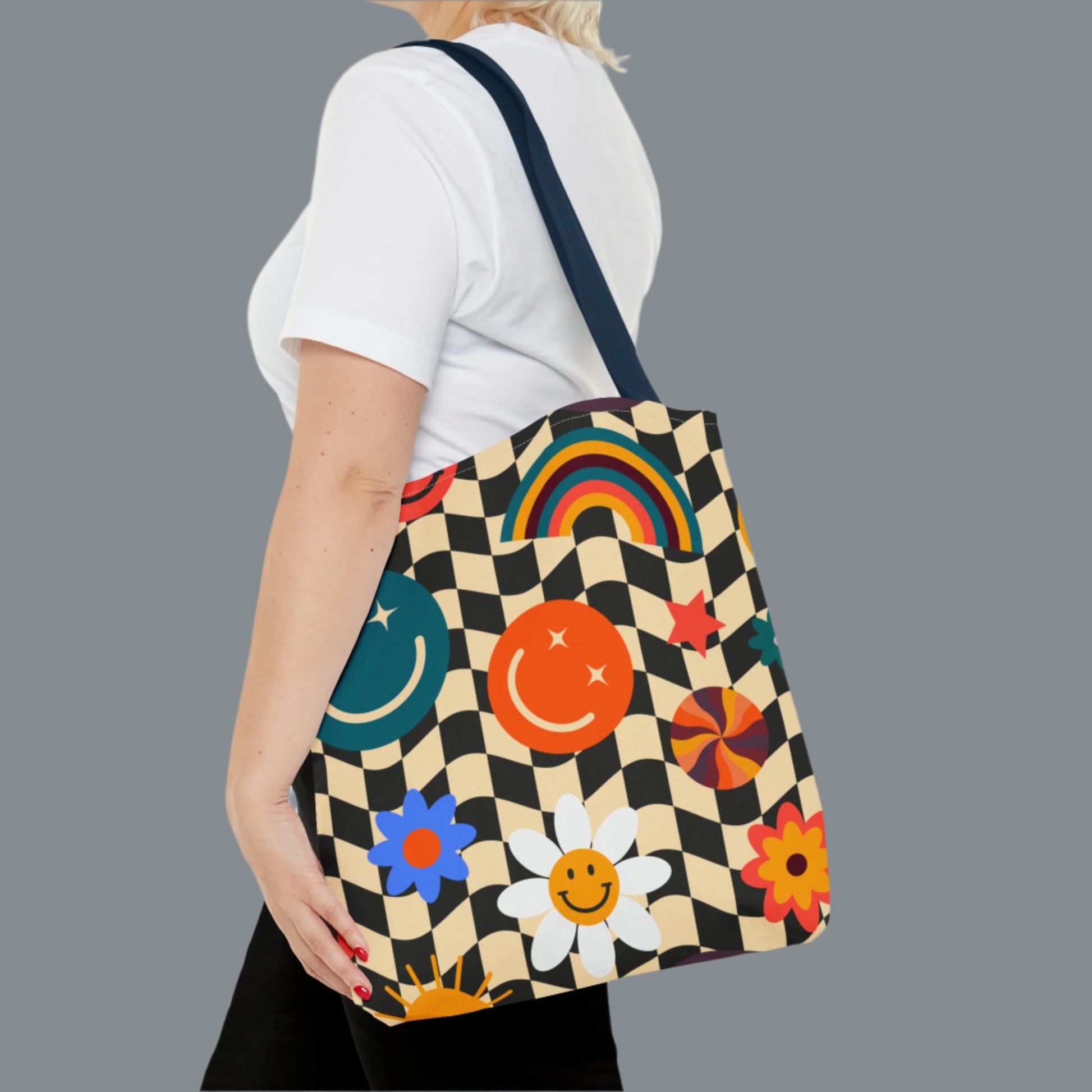 Smiley Face Checkerboard Canvas Tote Bag. This cute reusable carryall is eco friendly, and features a black and khaki checkerboard background, with smiley face, rainbow and daisy graphics. by jaecrece.com