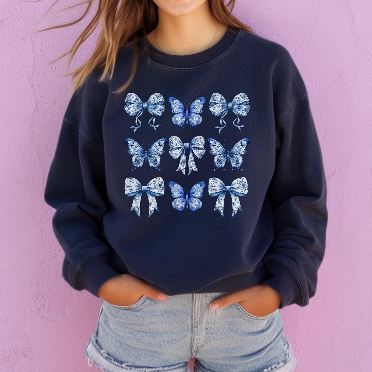 Image: Blue Toile Butterflies & Bows Women’s Sweatshirt in vintage-inspired print featuring butterflies and bows, perfect for moms embracing Texas coquette style. Made with soft fabric and designed for comfort, this sweatshirt is part of a family matching collection that includes toddler and girls options. Ideal for springtime events, Southern brunches, or coastal cowgirl fashion lovers who want casual elegance, by jaecrece.