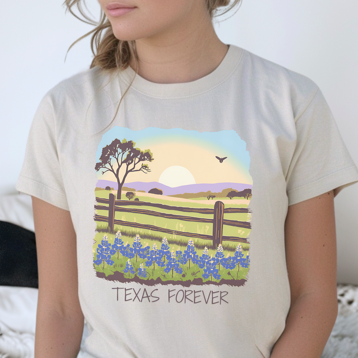 Image: A Texas-inspired graphic tee featuring a stunning sunset over a bluebonnet-filled field, symbolizing the natural beauty of the Lone Star State. With "Texas Forever" displayed in bold lettering, this T-shirt is a tribute to the wildflower season and Texas pride. Great for outdoor adventures, casual outings, or music festivals. The perfect way to wear your love for Texas wherever you go, by jaecrece.