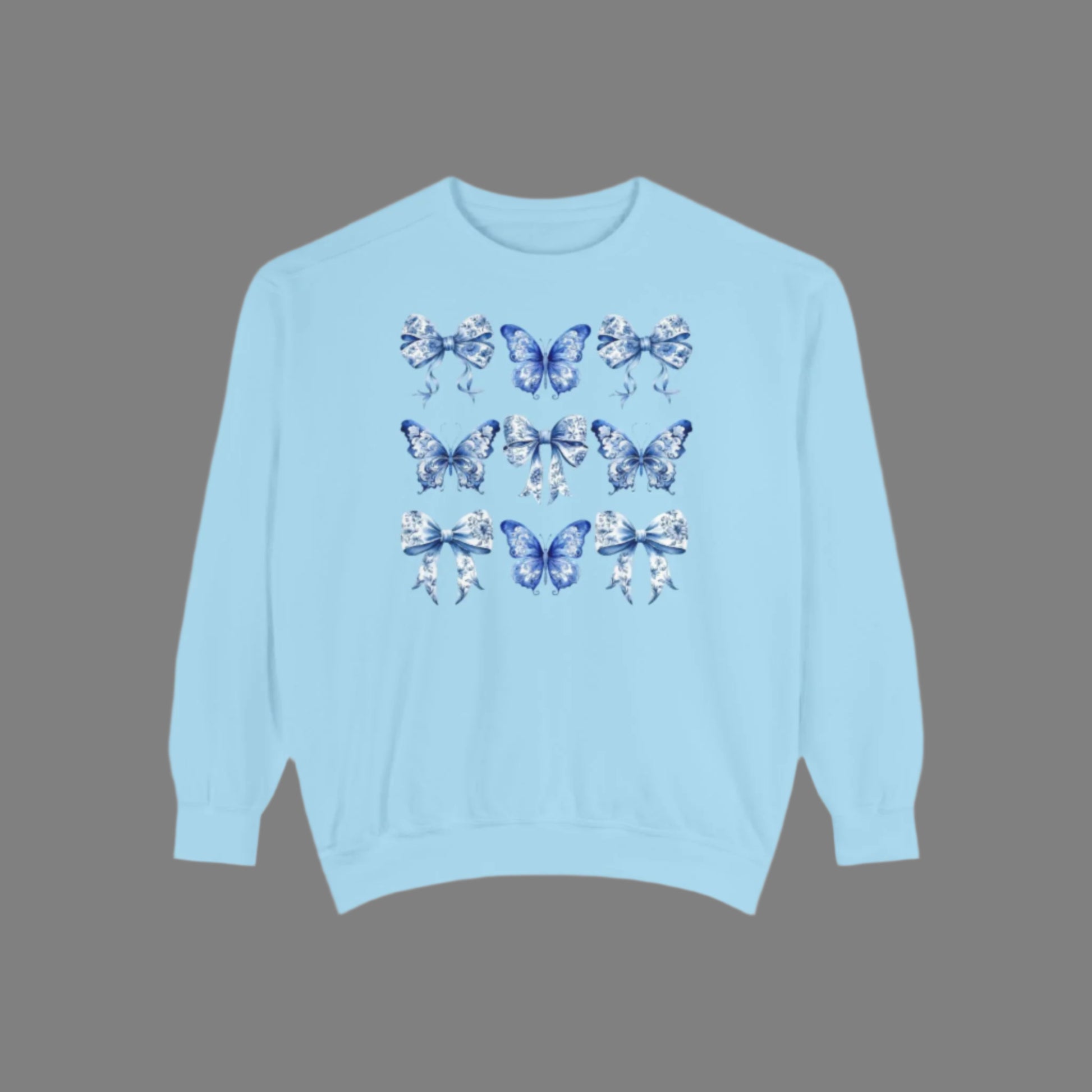 Image: Elegant yet comfortable sweatshirt for women with blue toile butterflies and bows, blending classic charm with modern softness. Sized XS to XL and designed for matching with toddlers and girls, this sweatshirt brings Texas coquette and coastal cowgirl fashion into the family wardrobe. A must-have for casual spring days, by jaecrece.