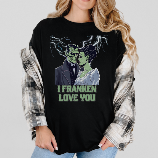 Black unisex Halloween shirt featuring a romantic Frankenstein and his bride under lightning, reading “I Franken Love You.” Soft Gildan 64000 tee, sizes S-5XL, perfect for couples, spooky parties, or as a Halloween gift for her or him. Ideal for Halloween humor, monster love, and festive casual wear.