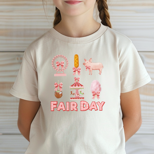Image: Celebrate fair season in this adorable Fair Day t shirt, featuring gingham lettering and a collection of nostalgic fair graphics like carnival rides, cotton candy, pigs, and corndogs. This feminine and stylish top has a coquette aesthetic, making it the perfect choice for state fairs, county fairs, or fun birthday celebrations. Available in sizes for toddlers, girls, and women, making it easy to create coordinated family outfits, by jaecrece.