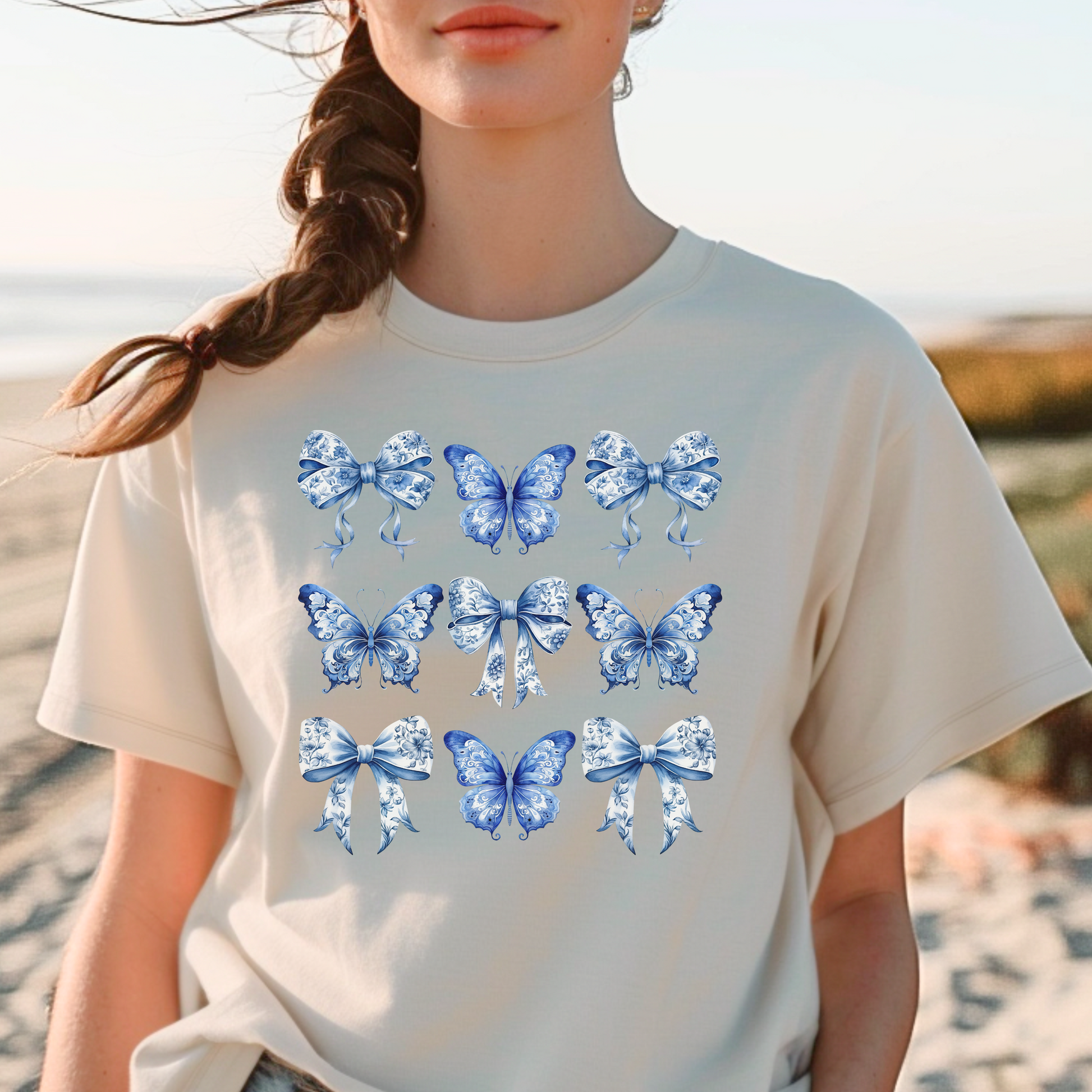 Image: Featuring a charming blue toile pattern with graceful butterflies and bows, this soft women’s shirt blends French countryside elegance with the trending soft girl aesthetic. Ideal for coastal cowgirl looks or stylish everyday wear, it’s a must-have for bougie mamas. Designed to match toddler and youth sizes, it’s part of our coordinated family collection and makes a beautiful gift for moms and daughters, by jaecrece.