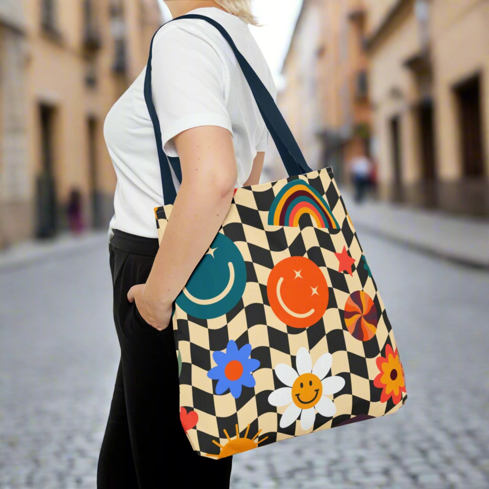 Smiley Face Checkerboard Canvas Tote Bag. This cute reusable carryall is eco friendly, and features a black and khaki checkerboard background, with smiley face, rainbow and daisy graphics. by jaecrece.com
