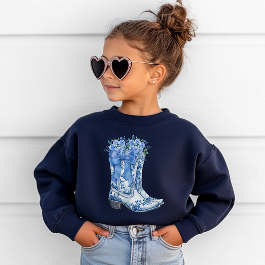 Image: Blue Toile Boots and Bows Sweatshirt in sizes for girls and toddlers. This pullover sweater features a pair of coastal cowgirl aesthetic cowboy boots with a blue bow and blue wildflowers. This country themed sweater makes a perfect gift for your daughter, by jaecrece