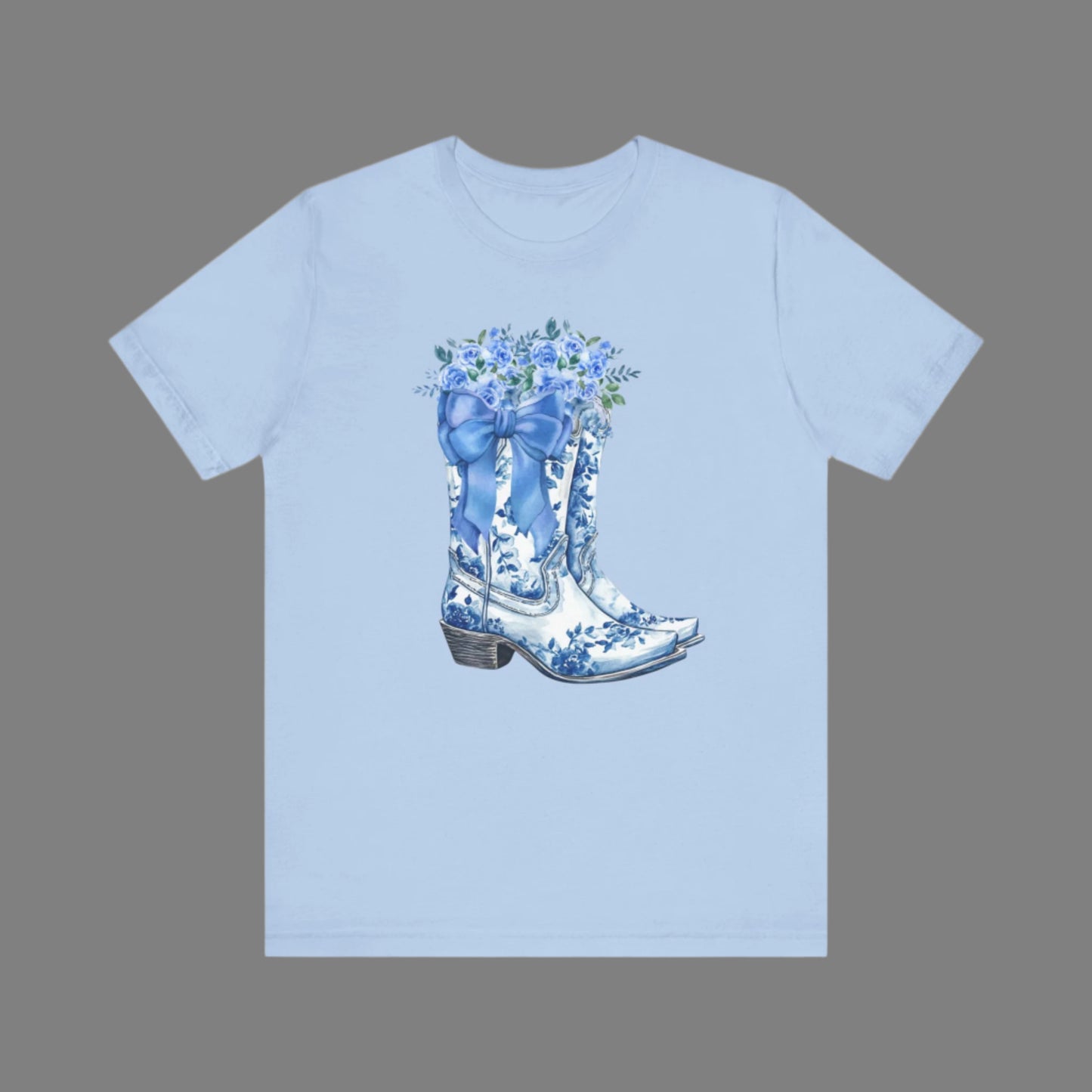 Image: Blue Toile Boots and Bows shirt in sizes for women. This pullover shirt features a pair of coastal cowgirl aesthetic cowboy boots with a blue bow and blue wildflowers. This country themed sweater makes a perfect gift for your daughter, or for the boujee mama in your life, by jaecrece