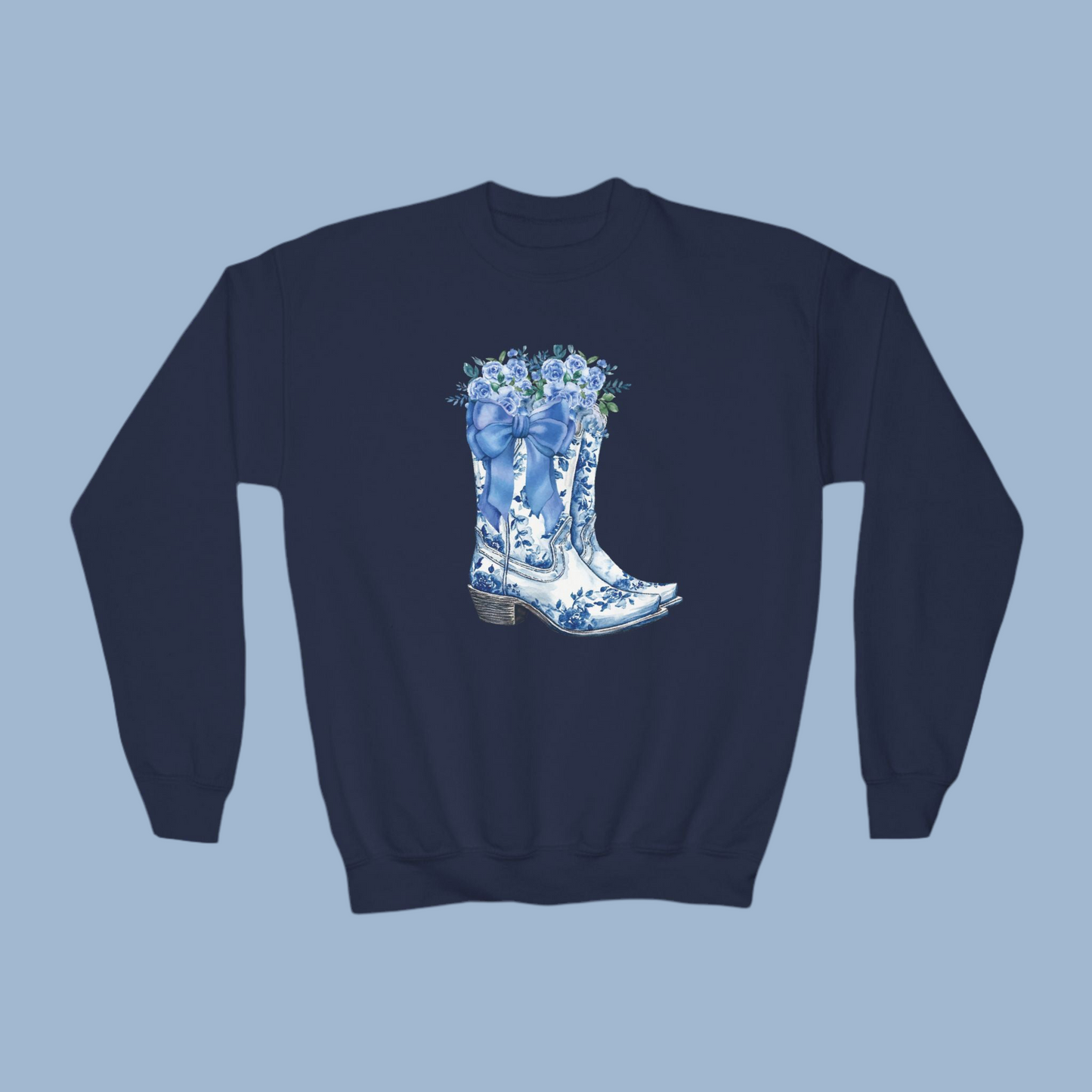 Image: Blue Toile Boots and Bows Sweatshirt in sizes for girls and toddlers. This pullover sweater features a pair of coastal cowgirl aesthetic cowboy boots with a blue bow and blue wildflowers. This country themed sweater makes a perfect gift for your daughter, by jaecrece
