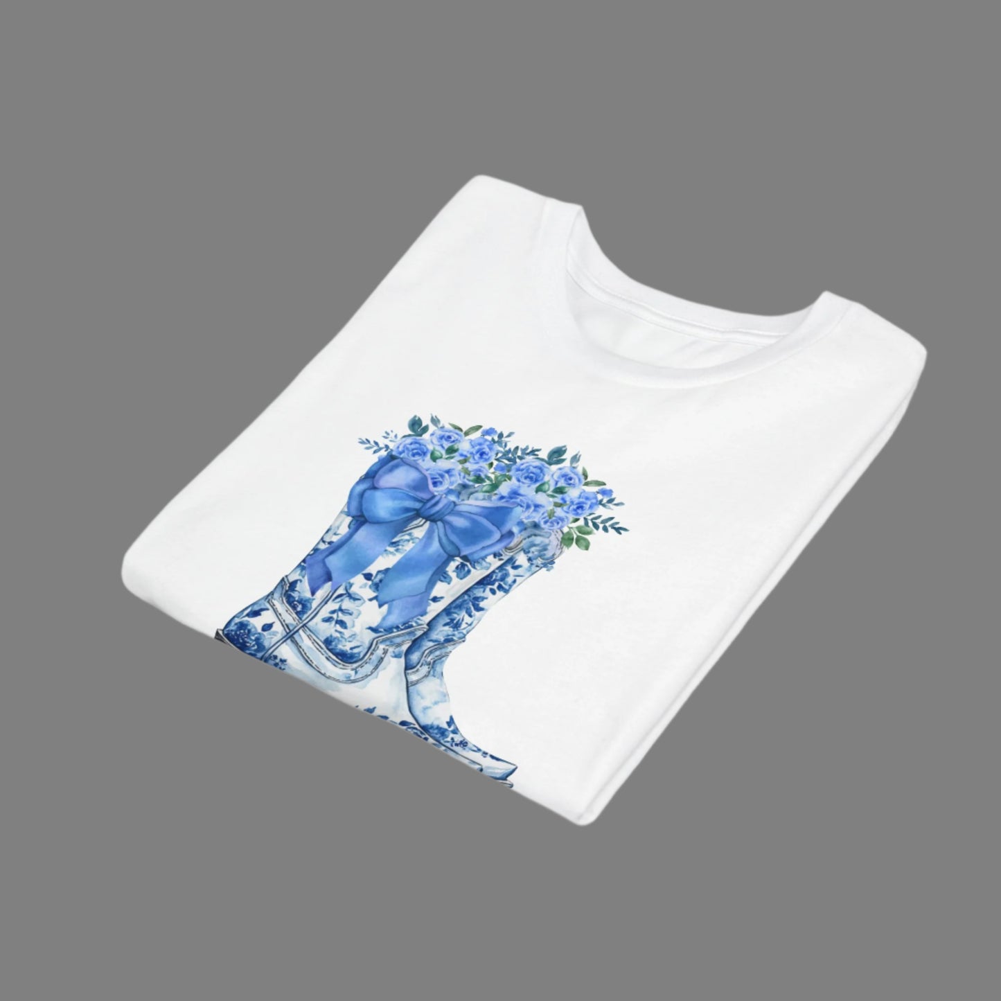 Image: A pretty twist on country wear, this youth tshirt in sizes S to XL features boots, bows, and wildflowers in a blue toile design. Perfect for the young cowgirl at heart, this cozy pullover is stylish enough for family gatherings and comfy enough for school. It makes a lovely gift for birthdays or holidays, and adds a vintage western vibe to any outfit, by jaecrece.