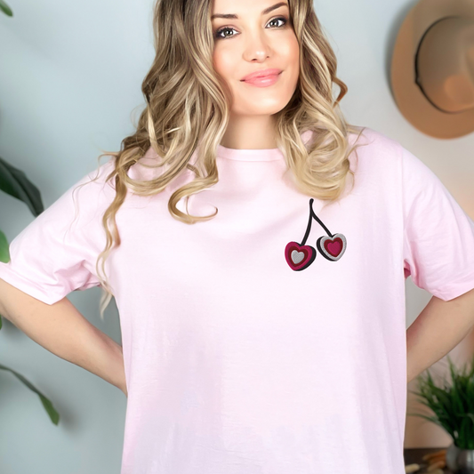 Image: A soft and stylish embroidered sweatshirt featuring a delicate cherry heart design, perfect for adding a touch of coquette charm to any outfit. The minimalist embroidery blends playful fruit-inspired fashion with a trendy aesthetic, making it an ideal gift for her. Whether worn for casual outings or as a cozy statement piece, this cherry bow shirt is both fashionable and comfortable, by jaecrece.