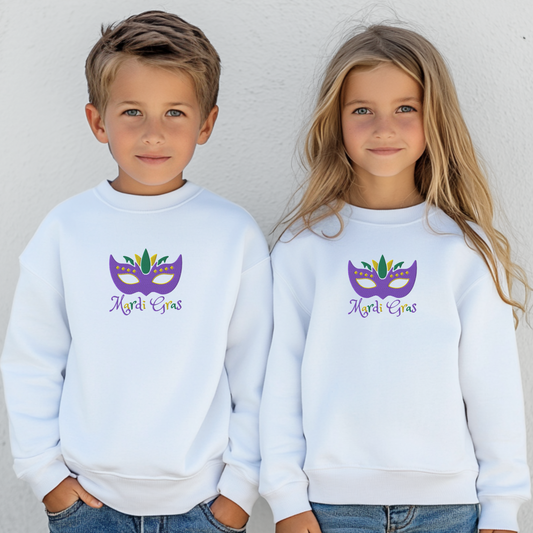 Youth Mardi Gras embroidered sweatshirt featuring a festive purple, green, and gold carnival mask and the text “Mardi Gras.” This cozy cotton blend sweatshirt is perfect for kids attending parades, school parties, or family celebrations. Available in youth sizes XS–XL and part of a coordinating family set with matching adult sizes for festive Mardi Gras fun.