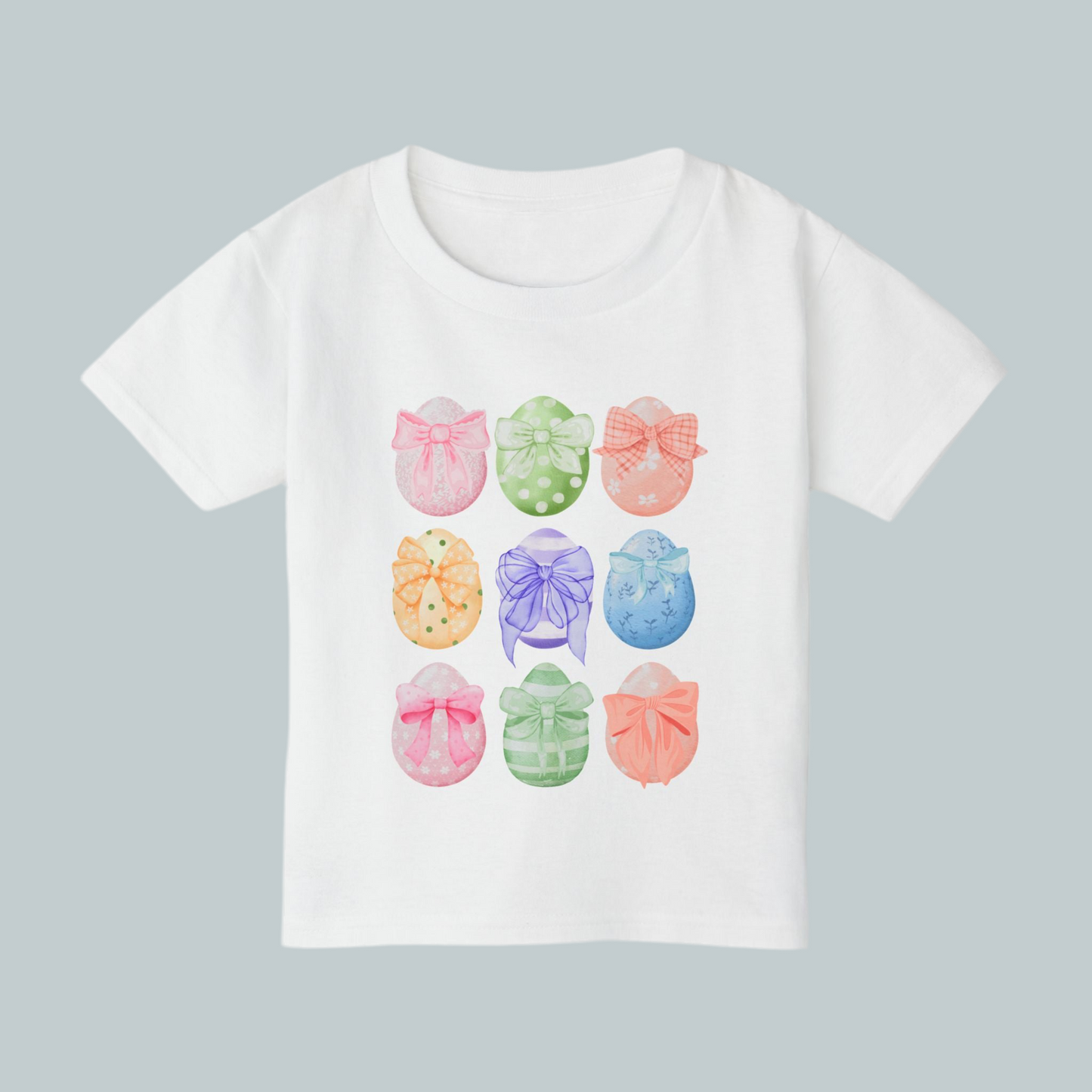 Image: Celebrate Easter with this adorable toddler shirt featuring nine watercolor eggs, each decorated with a dainty bow in coordinating pastel shades. This soft and stylish tee is perfect for spring festivities, making it an ideal choice for egg hunts, Easter brunch, and matching family outfits. With a charming design and cozy fit, this Easter tee is a wonderful gift idea and a great addition to any little girl’s wardrobe, by jaecrece.