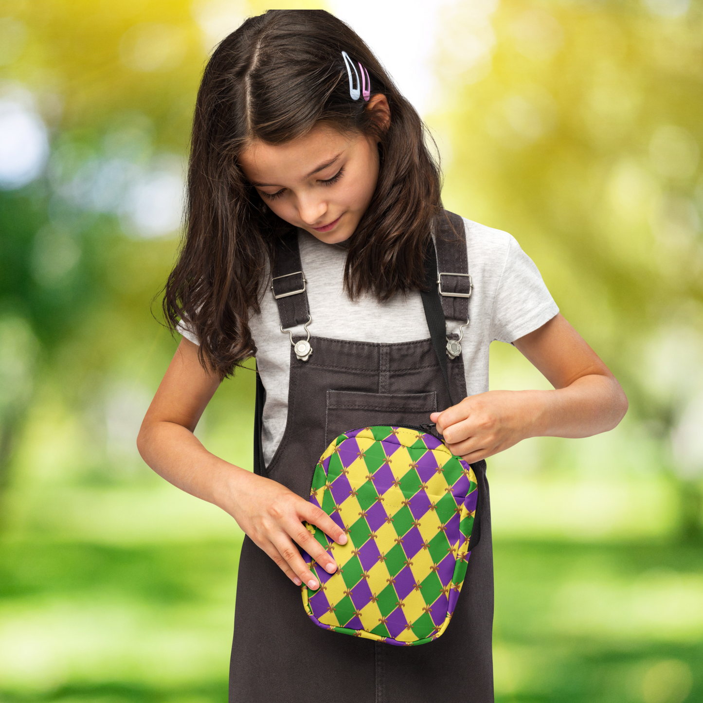 Versatile Mardi Gras bag featuring a green, purple, and gold harlequin checkerboard pattern. Use it as a crossbody, mini backpack, or sling bag for New Orleans Carnival fun. Lightweight and water-resistant, this bag keeps essentials secure while you enjoy parades and French Quarter festivities. Designed for Mardi Gras lovers, with matching girls’ and women’s leggings available for a festive family look.