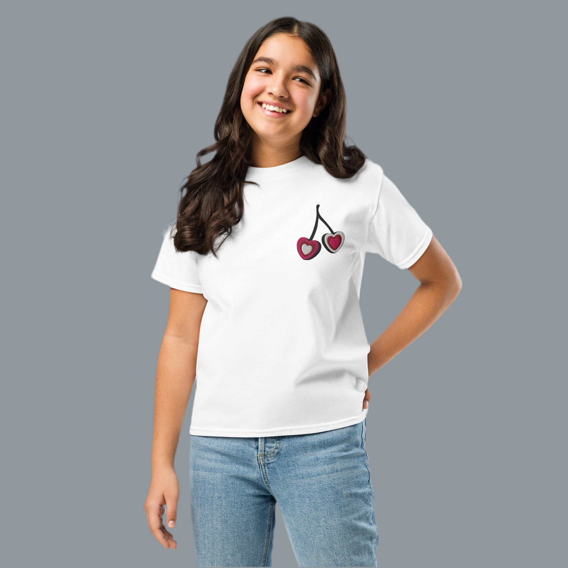 Image: Cherry Embroidery Shirt for Girls. This Valentines Day crewneck tee features two embroidered cherries on the left chest in red, pink and white with black stems. Great gift for tweens and toddlers who love the cherrycore aesthetic, by jaecrece