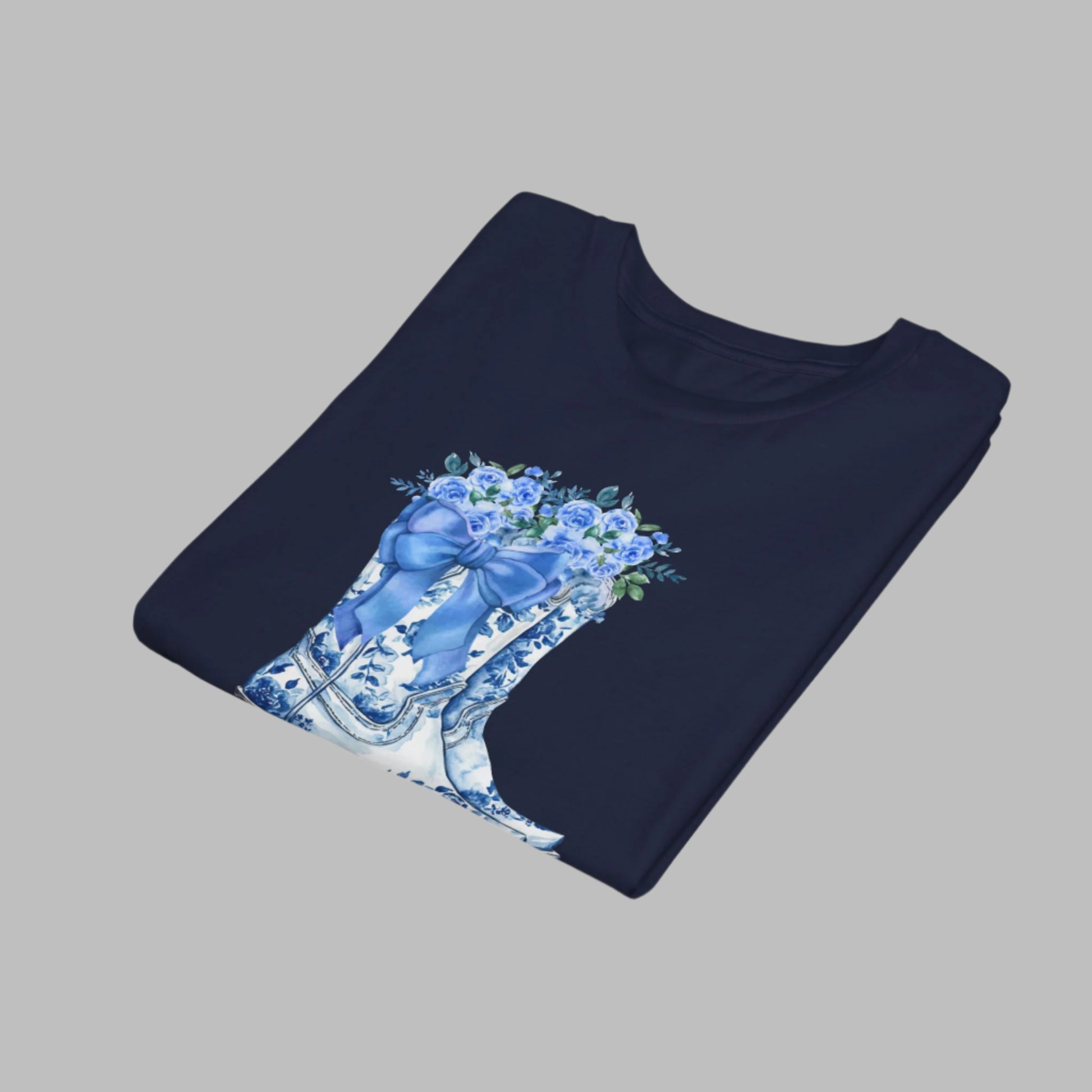 Image: Blue Toile Boots and Bows shirt in sizes for women, girls and toddlers. This pullover shirt features a pair of coastal cowgirl aesthetic cowboy boots with a blue bow and blue wildflowers. This country themed sweater makes a perfect gift for your daughter, or for the boujee mama in your life, by jaecrece