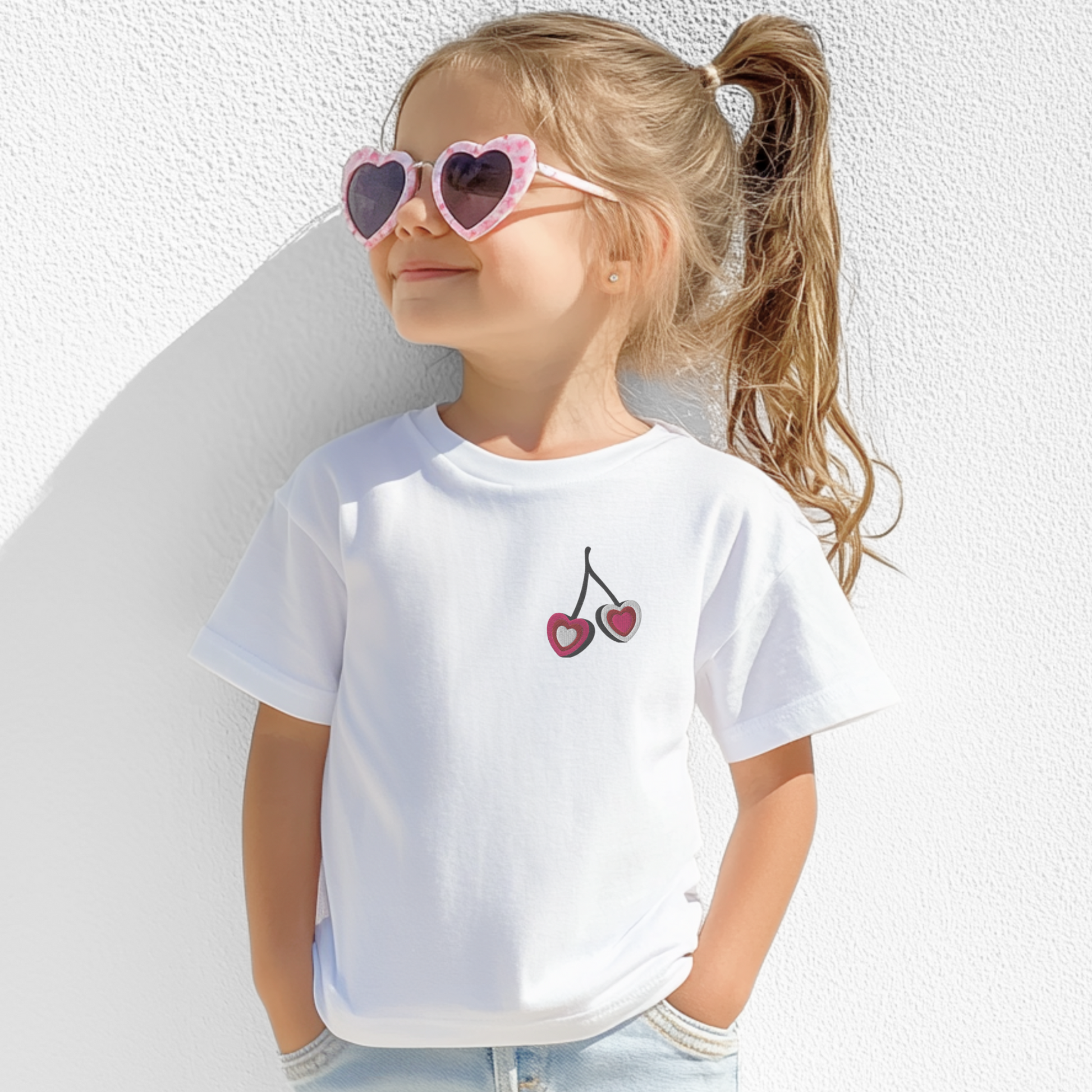 Image: Cherry Embroidery Shirt for Girls. This Valentines Day crewneck tee features two embroidered cherries on the left chest in red, pink and white with black stems. Great gift for tweens and toddlers who love the cherrycore aesthetic, by jaecrece