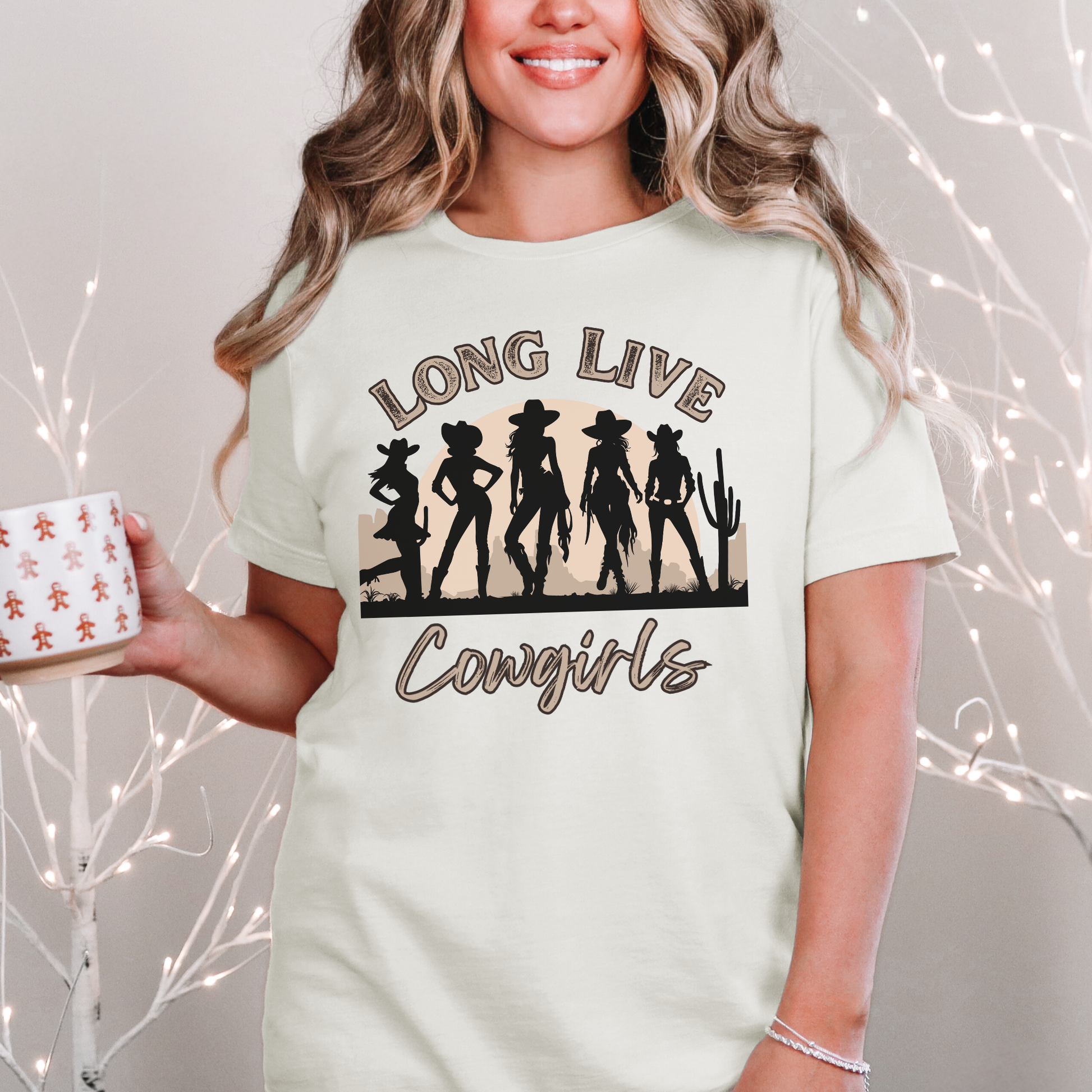 Image: A soft, oversized country tee with Long Live Cowgirls printed above five bold cowgirl figures, bringing vintage western style to life. The relaxed fit and earthy tones make it the perfect choice for music festivals, rodeos, and everyday country wear. Whether you are a true western spirit or just love rustic fashion, this shirt blends comfort and charm effortlessly, by jaecrece.