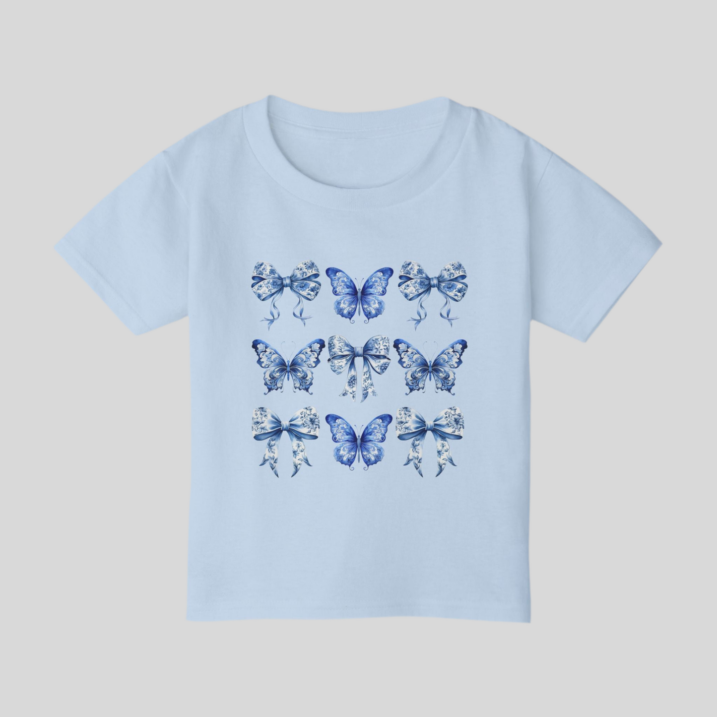 Blue Toile toddler tee for girls features a classic butterfly and bow motif in soft blue hues, perfect for fans of cottagecore, Texas coquette trends, and coastal cowgirl style. Designed for comfort and charm, this cute spring shirt for toddlers is ideal for everyday play or family matching moments. Sizes 2T to 6T make it easy to twin with older siblings or moms. An aesthetic, versatile gift for fashionable little ones, by jaecrece.