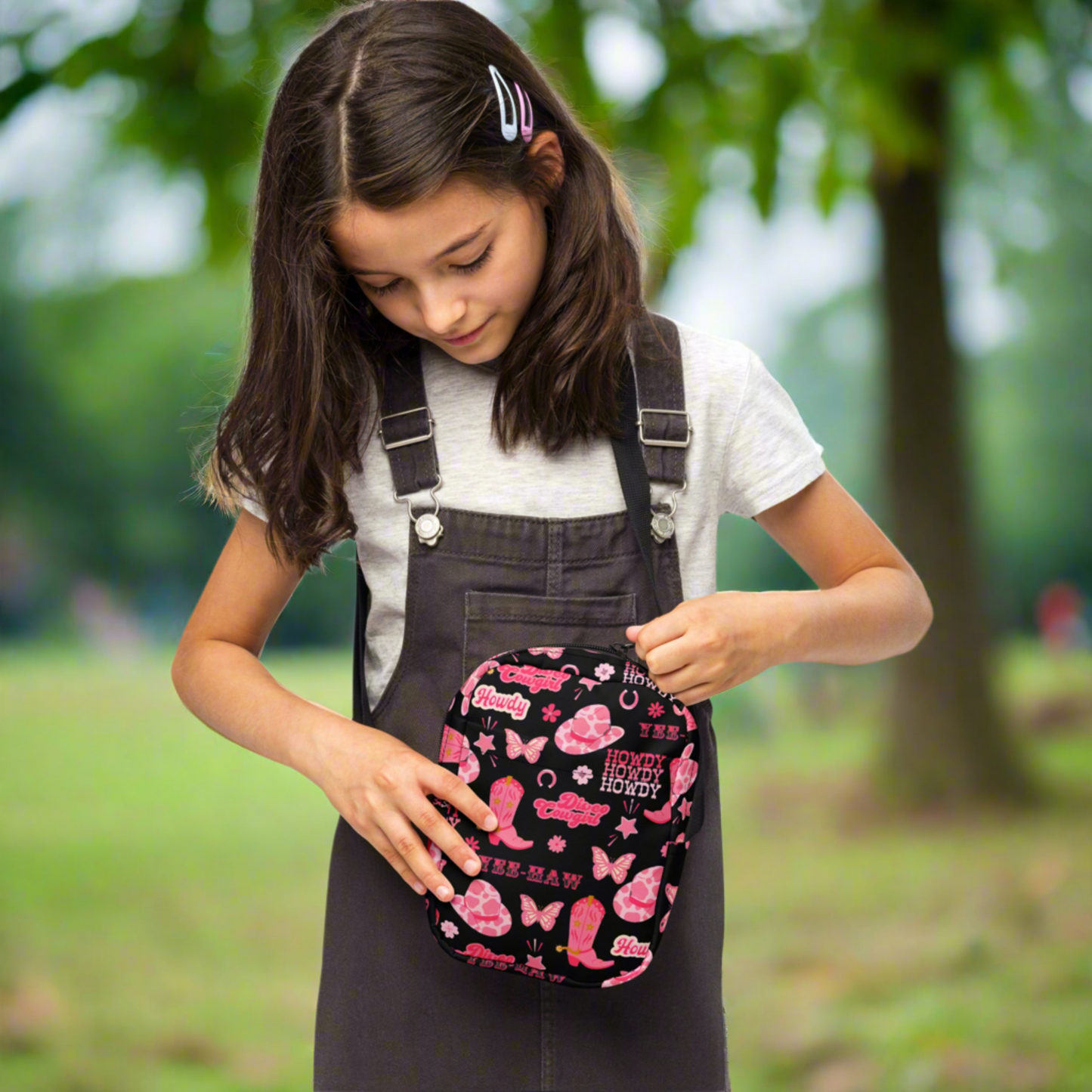 Image: Disco Cowgirl Canvas Crossbody Bag. This small black sling bag features a western glam hot pink pattern of cowgirl boots, cowgirl hats, butterflies and horseshoes. The pattern reads Disco Cowgirl, Yee-Haw and Howdy. The perfect mini backpack for bachelorette parties, gifts for teens or tweens, or trips to the state fair, by jaecrece
