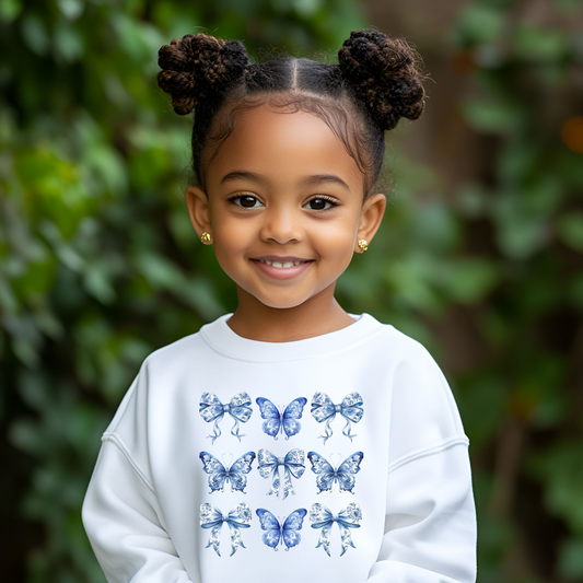 Image: Blue Toile Girls Sweatshirt with butterflies and bows design, inspired by Texas coquette and coastal cowgirl style. Available in sizes XS to XL for tweens and teens. Perfect for Southern-inspired family matching outfits. Features soft fabric and classic blue toile pattern, ideal for spring, fall, and casual outings. A trendy wardrobe staple for girls who love charming and vintage looks with a modern touch, by jaecrece.