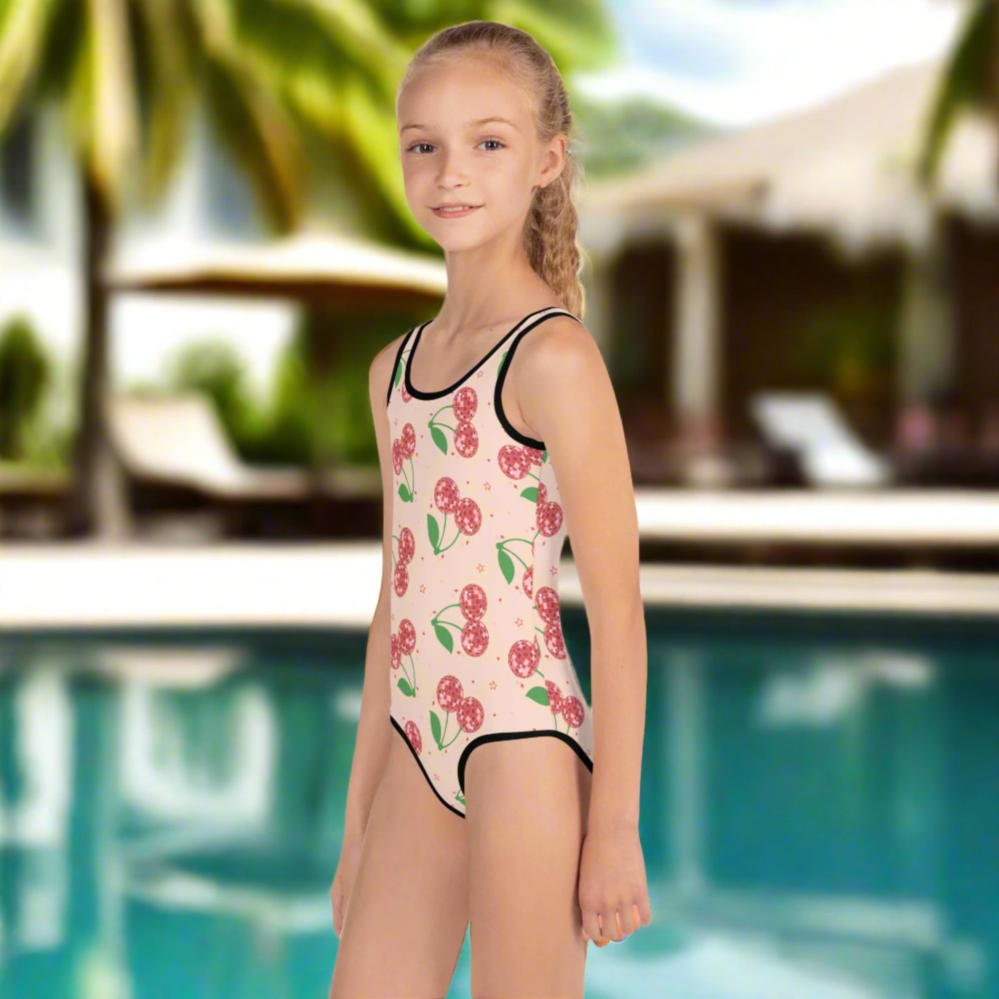 Disco Cherries girls swimsuit in toddler sizes 2T–7, made with UPF 38–40 sun protection and soft microfiber stretch fabric. Red disco cherries pop against a pink background for a fun, eye-catching look. Ideal for beach days, pool playdates, or vacation twinning. Matches perfectly with our adult-sized version for coordinated family swimwear that’s stylish and fun.