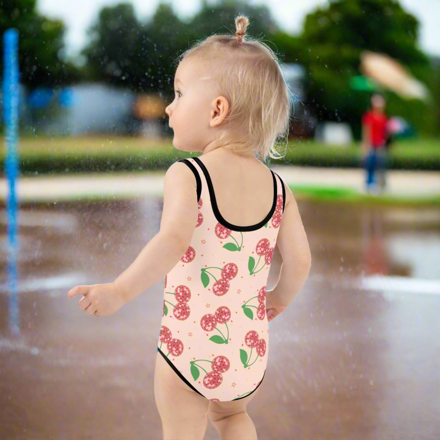 Pink girls’ one-piece swimsuit with red disco cherries, available in toddler sizes 2T–7 and made with soft, stretchy fabric. UPF 38–40 offers sun safety while the double-layered front ensures comfort. This toddler swimwear is part of a family matching swimsuit collection, also available in adult sizes. Perfect for trend-loving moms who want playful, coordinated looks at the pool or beach.