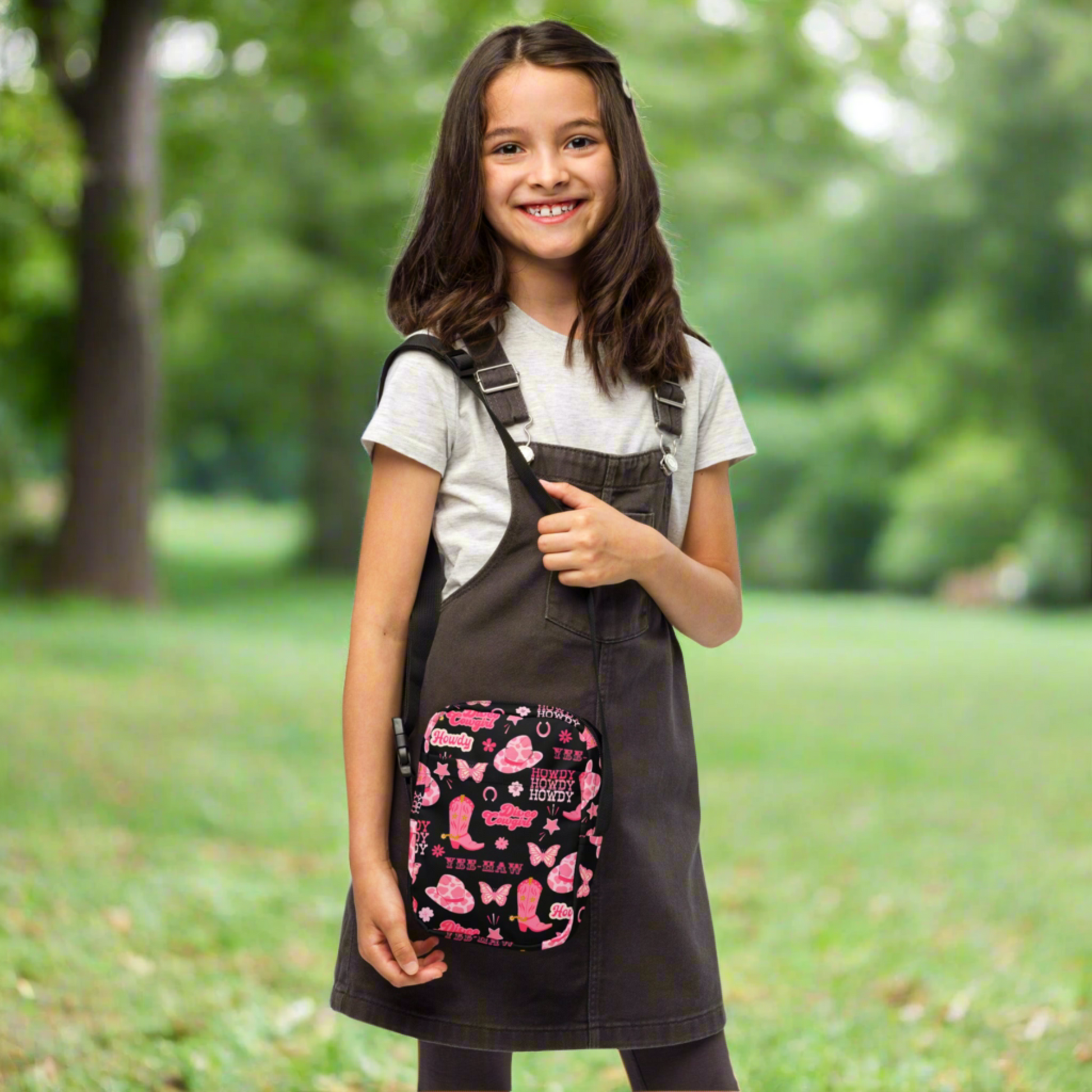 Image: Disco Cowgirl Canvas Crossbody Bag. This small black sling bag features a western glam hot pink pattern of cowgirl boots, cowgirl hats, butterflies and horseshoes. The pattern reads Disco Cowgirl, Yee-Haw and Howdy. The perfect mini backpack for bachelorette parties, gifts for teens or tweens, or trips to the state fair, by jaecrece