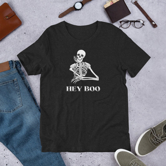 Unisex Hey Boo Skeleton T-Shirt in Black Heather, printed on Bella Canvas 3001, available in sizes XS–5XL. This Halloween graphic tee features a flirty skeleton with the playful phrase “Hey Boo,” making it the perfect funny Halloween shirt for parties, pumpkin patch outings, or everyday fall outfits. Lightweight, soft, and comfortable, this spooky season tee is a festive way to celebrate Halloween with humor, charm, and style.