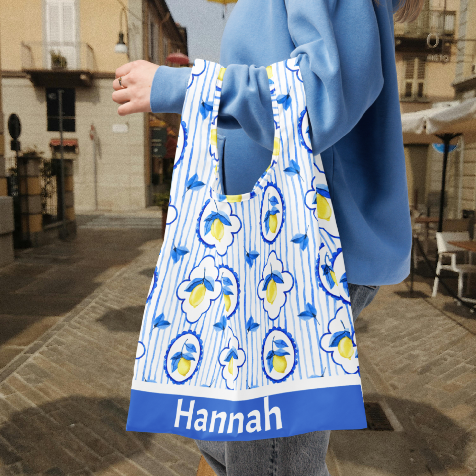 Eco friendly Amalfi Lemon Tote Bag with chic Italian coastal style, featuring watercolor lemons, Mediterranean tile accents, and sturdy integrated handles that won’t break under weight. Lightweight yet strong, this washable reusable bag is perfect for farmers market shopping, groceries, travel, or beach vacations. Bag measures 15.5" × 25.3" unfolded and folds into a small pouch with an elastic band for easy storage.