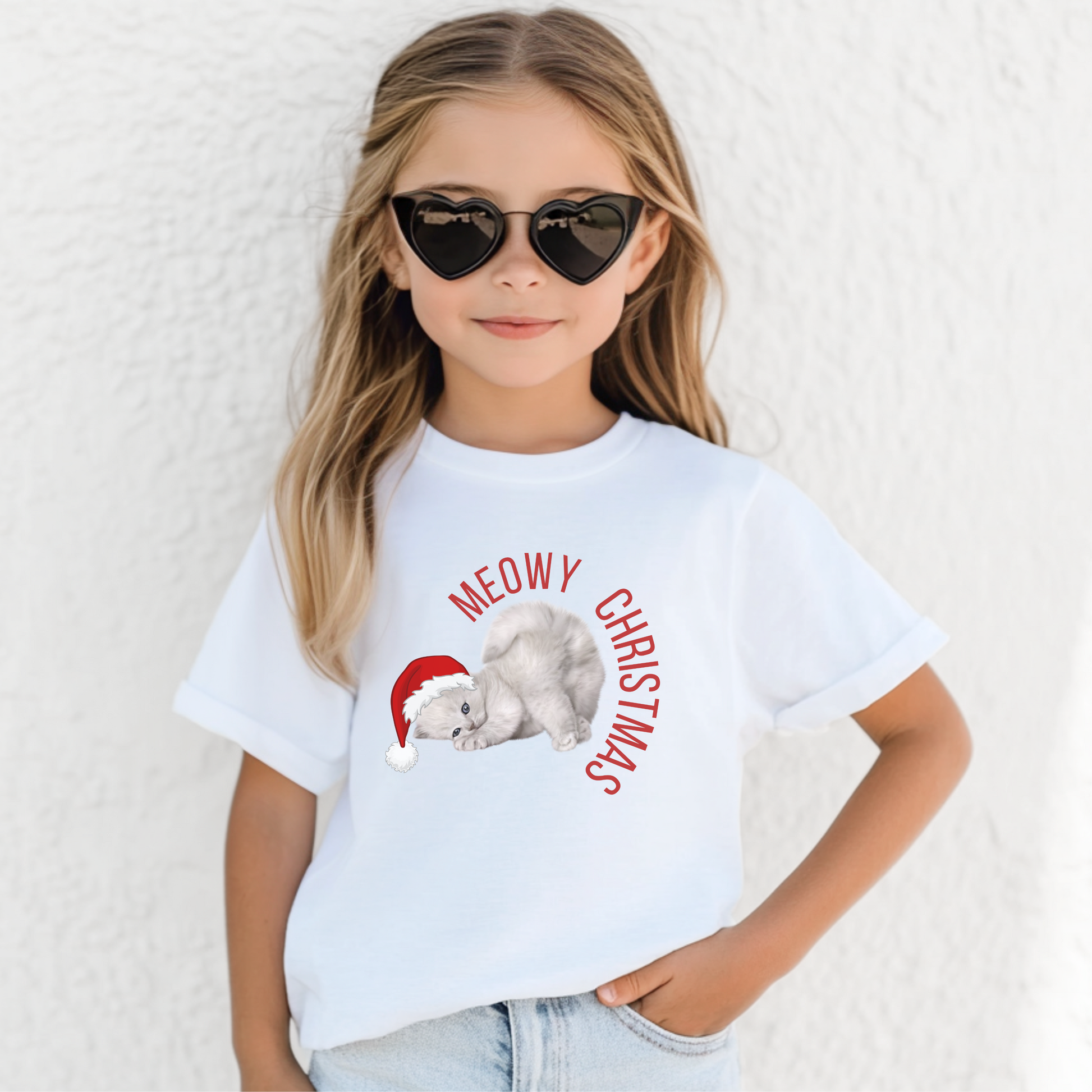 Youth unisex Meowy Christmas shirt featuring a gray kitten with blue eyes wearing a Santa hat. This festive kids' holiday shirt is perfect for cat lovers, Christmas family photos, and matching sibling outfits. Available in sizes S–XL, this Christmas cat tee brings together cozy comfort, holiday cheer, and playful style. Great for winter celebrations, Christmas pajamas, or holiday events with family and friends.