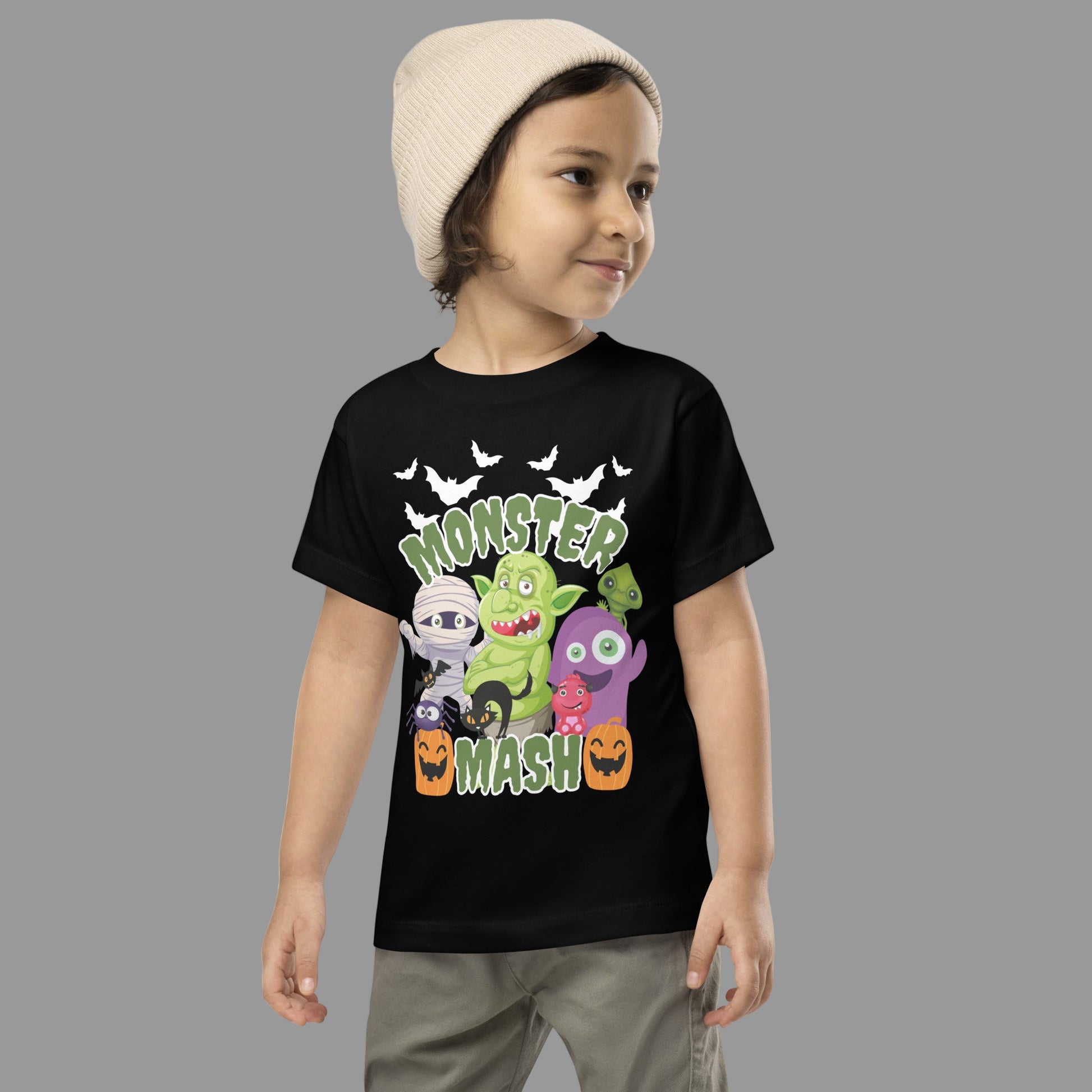 Toddler Monster Mash t-shirt in black, sizes 2T–5T, with colorful Halloween monster illustrations including a mummy, troll, pumpkins, bat, and cat. Made for toddlers who love spooky fun, this Halloween graphic tee is comfortable and durable for fall activities. A perfect family matching Halloween shirt idea for group costumes, mommy and me sets, and sibling outfits, this toddler monster shirt is festive and playful for October.