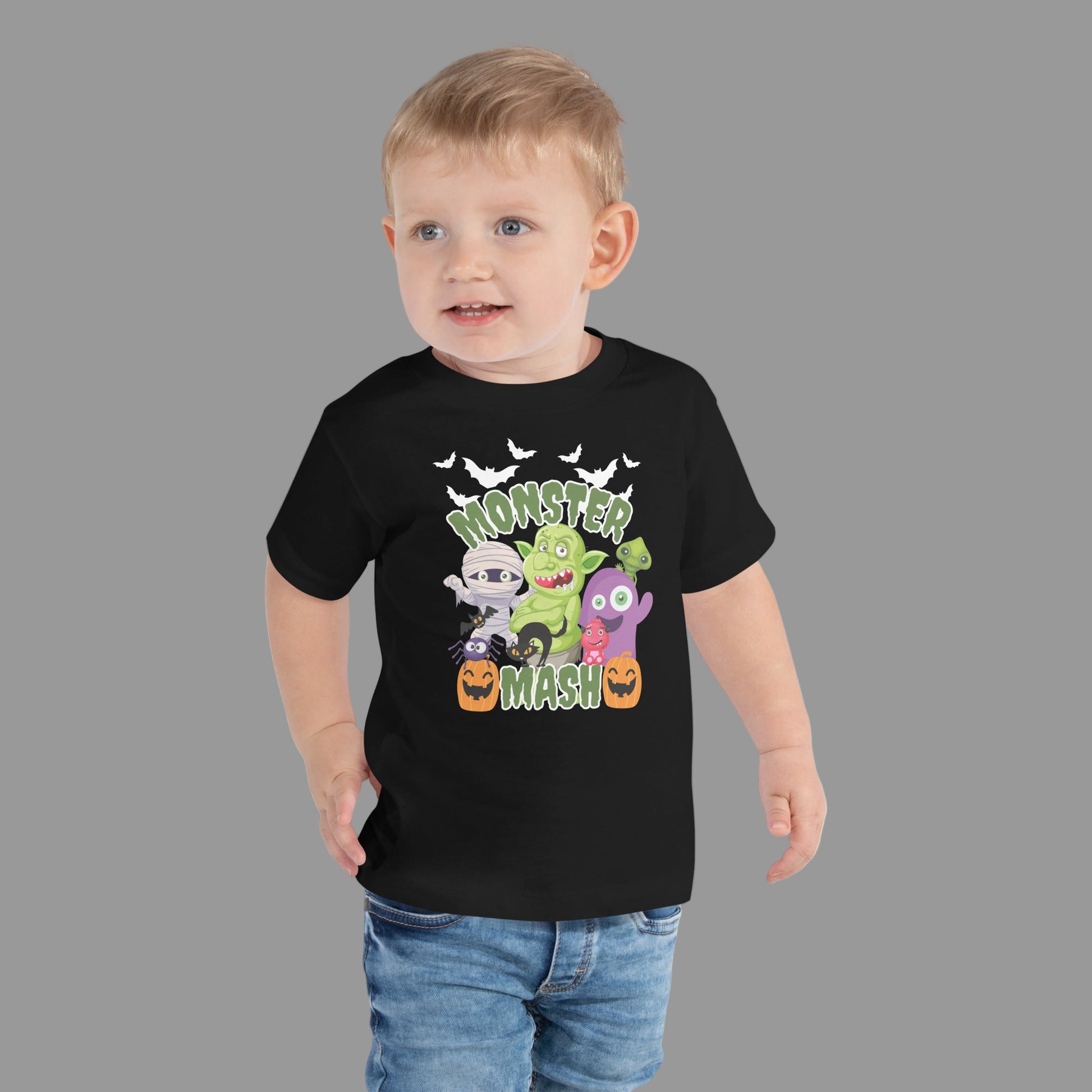 Monster Mash toddler Halloween shirt in black, made from soft fabric and sized 2T–5T, showcasing fun cartoon monsters including mummy, pumpkin, cat, and bats. This toddler Halloween tee is perfect for trick-or-treating, preschool Halloween parties, or pumpkin patch visits. A family matching monster shirt for sibling sets and mommy and me outfits, this festive toddler graphic t-shirt makes a spooky yet adorable fall outfit.
