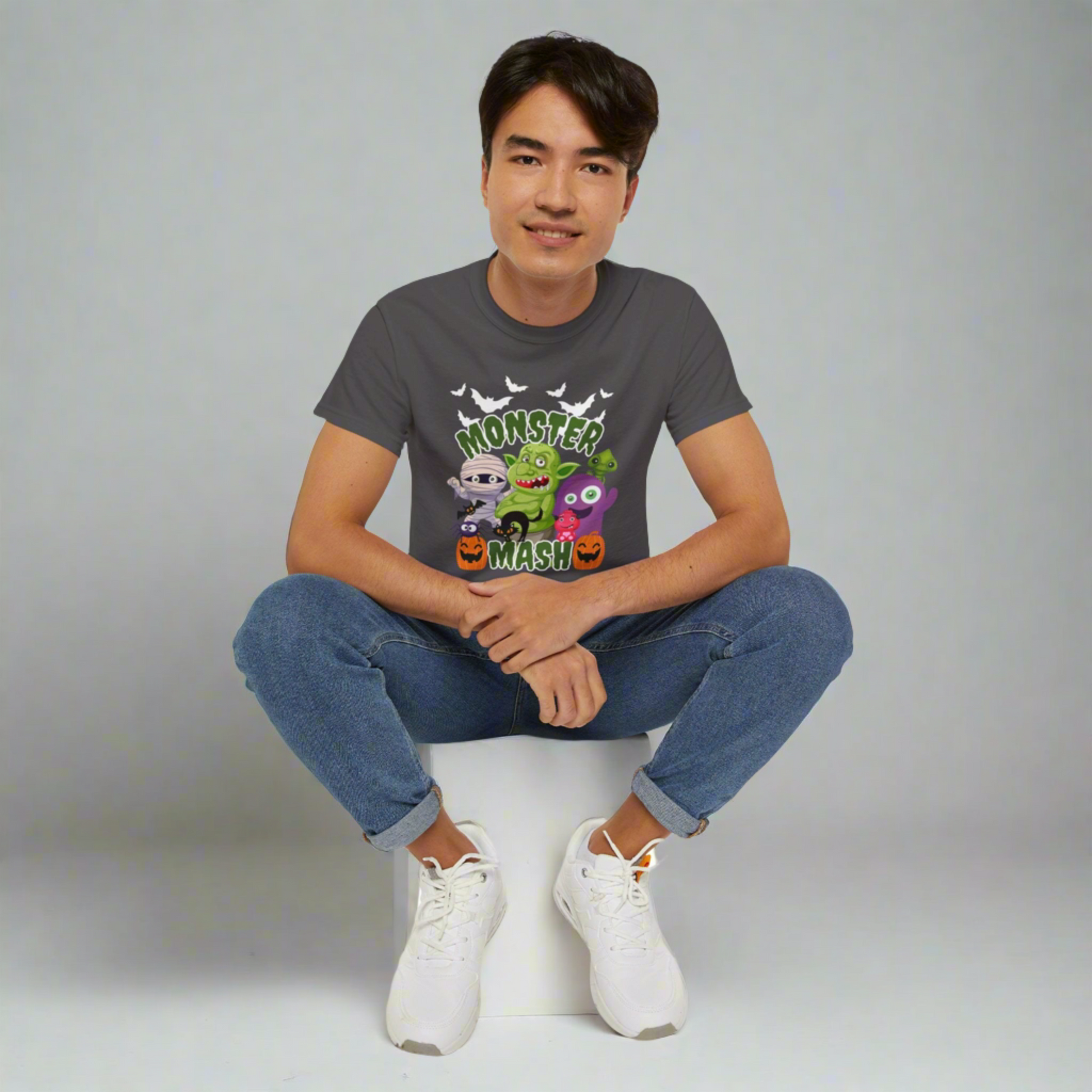 Halloween graphic t-shirt in black, showcasing a bold Monster Mash cartoon design with classic Halloween characters like a mummy, pumpkins, bats, a troll, and a spider. Made from 100% cotton on the durable Gildan 2000 shirt, this unisex tee is soft, breathable, and available in adult sizes S–5XL. Great for matching spooky season outfits, Halloween parties, trick-or-treating, or everyday October wear, this shirt makes a unique gift for Halloween lovers.