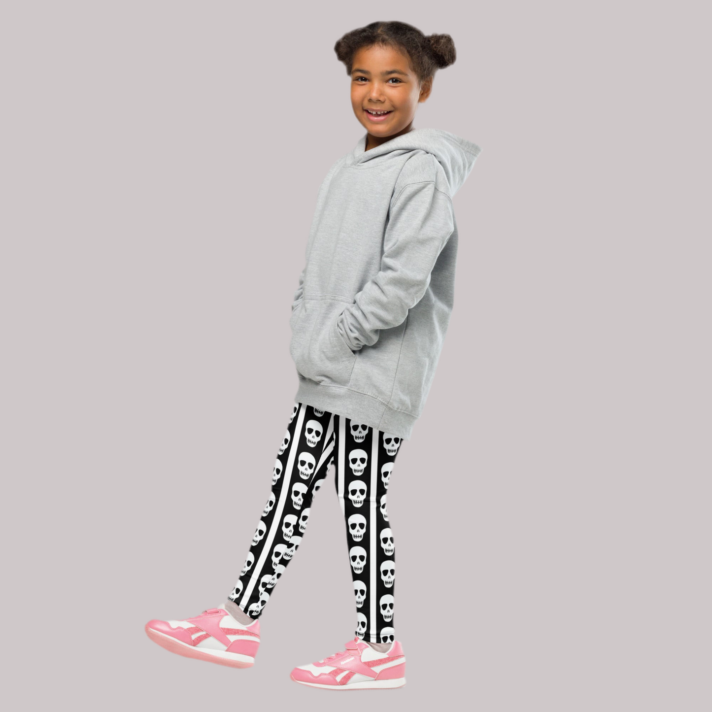 Image: These fun kids leggings feature bold black and white vertical stripes with a playful row of skulls running down each leg. Designed for toddlers and children who love spooky style or Halloween vibes, these leggings offer comfort and stretch for active play. Available in toddler and youth sizes, they are perfect for dress-up days, theme parties, or everyday outfits with a little edge, by jaecrece.