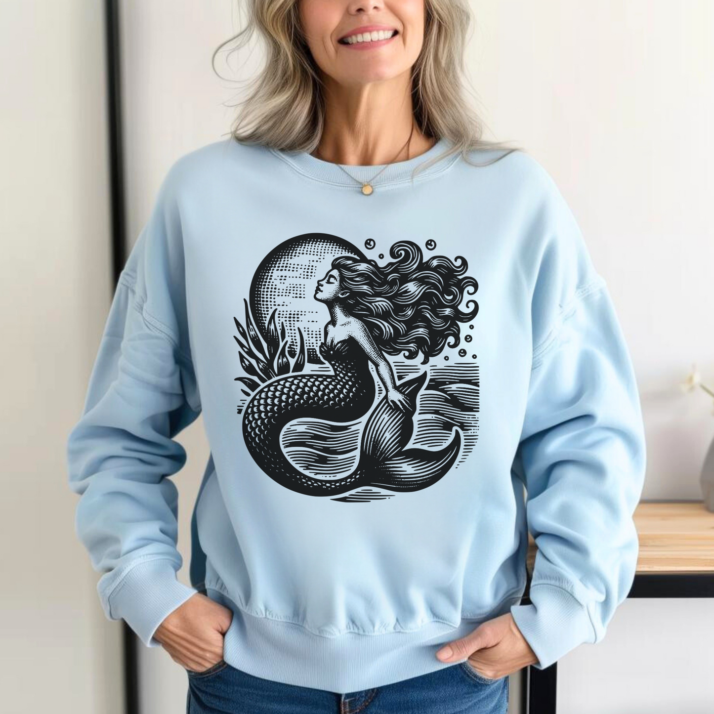 Vintage mermaid sweatshirt printed on a Comfort Colors 1566 crewneck in Chambray This ocean-inspired pullover features a detailed black mermaid graphic with flowing hair and sea elements, perfect for women, teens, and coastal style lovers. A soft and relaxed fit makes it ideal for everyday wear, lounging, or gifting for birthdays, holidays, or anyone who loves nautical fashion, sea life, or fantasy-inspired clothing.