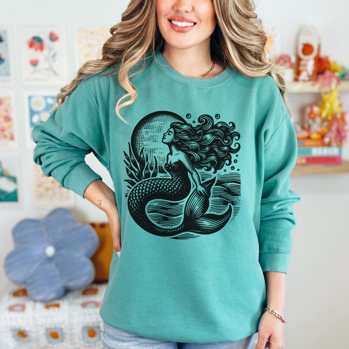 Mermaid sweatshirt printed on Comfort Colors 1566 crewneck in Seafoam green. Showcasing a bold vintage-style mermaid design surrounded by waves and sea plants, this cozy pullover blends whimsical fantasy with coastal charm. Made from a soft cotton blend, it’s a relaxed fit that’s perfect for everyday outfits, lounging, or layering. Available in sizes S–3XL, this nautical ocean-themed sweatshirt is an ideal gift for women, teens, and beach lovers who enjoy unique coastal fashion.