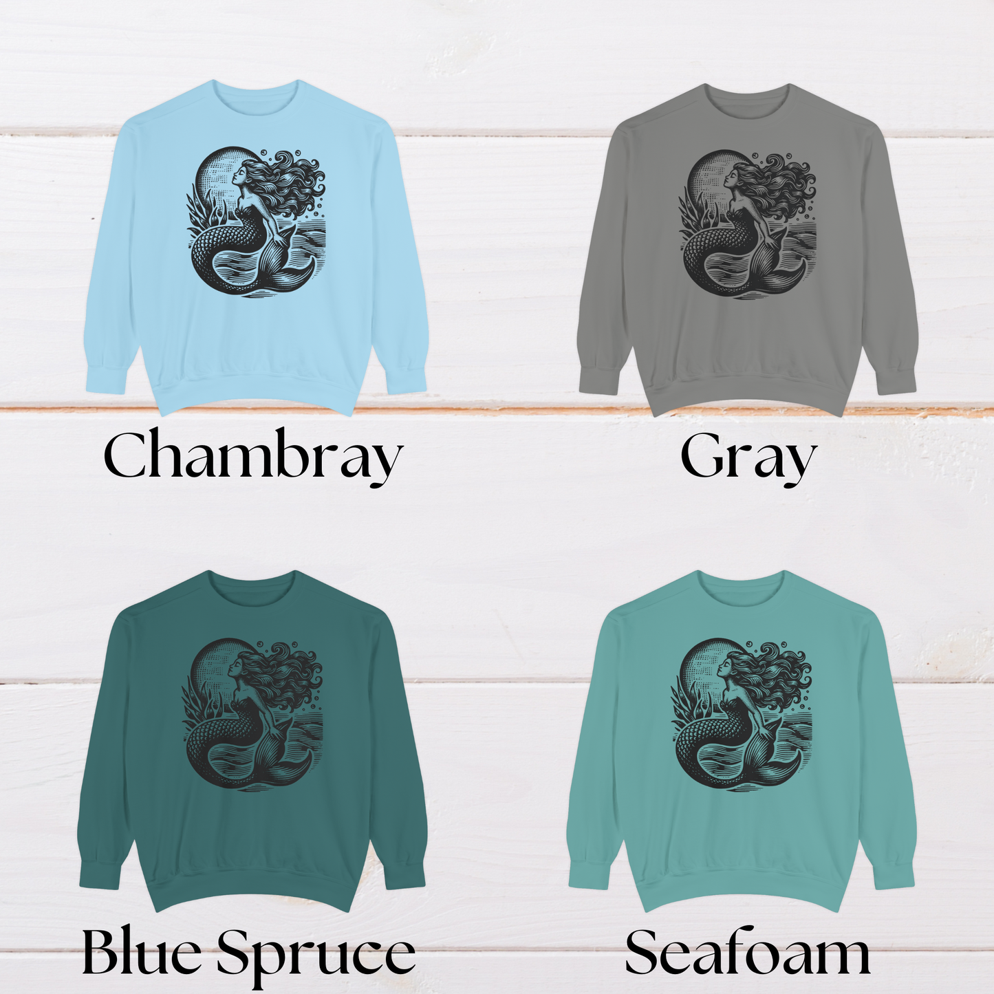 Comfort Colors 1566 sweatshirt featuring a vintage-style mermaid design in black ink. Shown in a flat lay, this ocean graphic pullover is available in Blue Spruce, Chambray, Grey, and Seafoam, sizes small through 3XL. With a soft cotton blend and relaxed fit, this whimsical sweatshirt makes a thoughtful gift for beach lovers, women, and teens who adore nautical fashion, cozy coastal wear, or fantasy-inspired clothing.